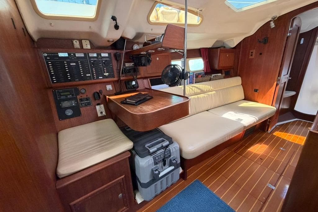 Interior of a 2002 Hunter 410 sailboat with wood paneling and navigation equipment.