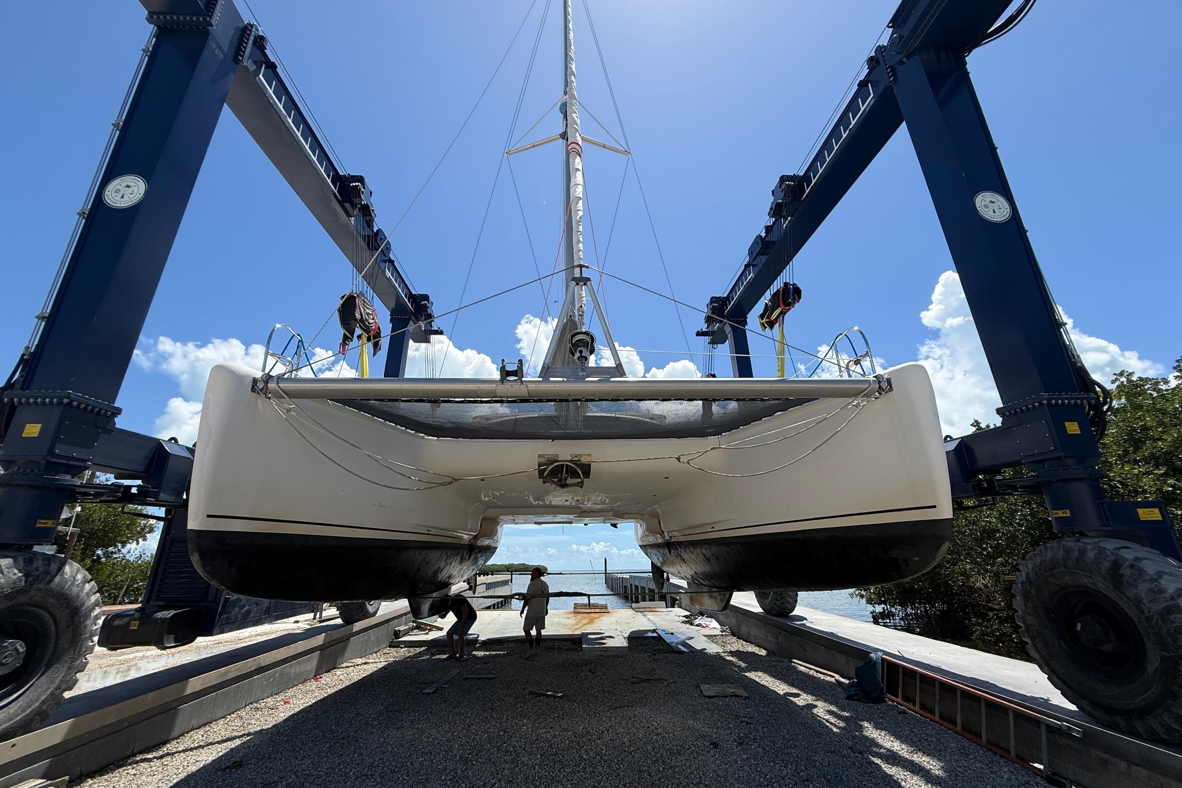 1995 Fountaine Pajot Athena 38 catamaran lifted by crane, clear sky background.