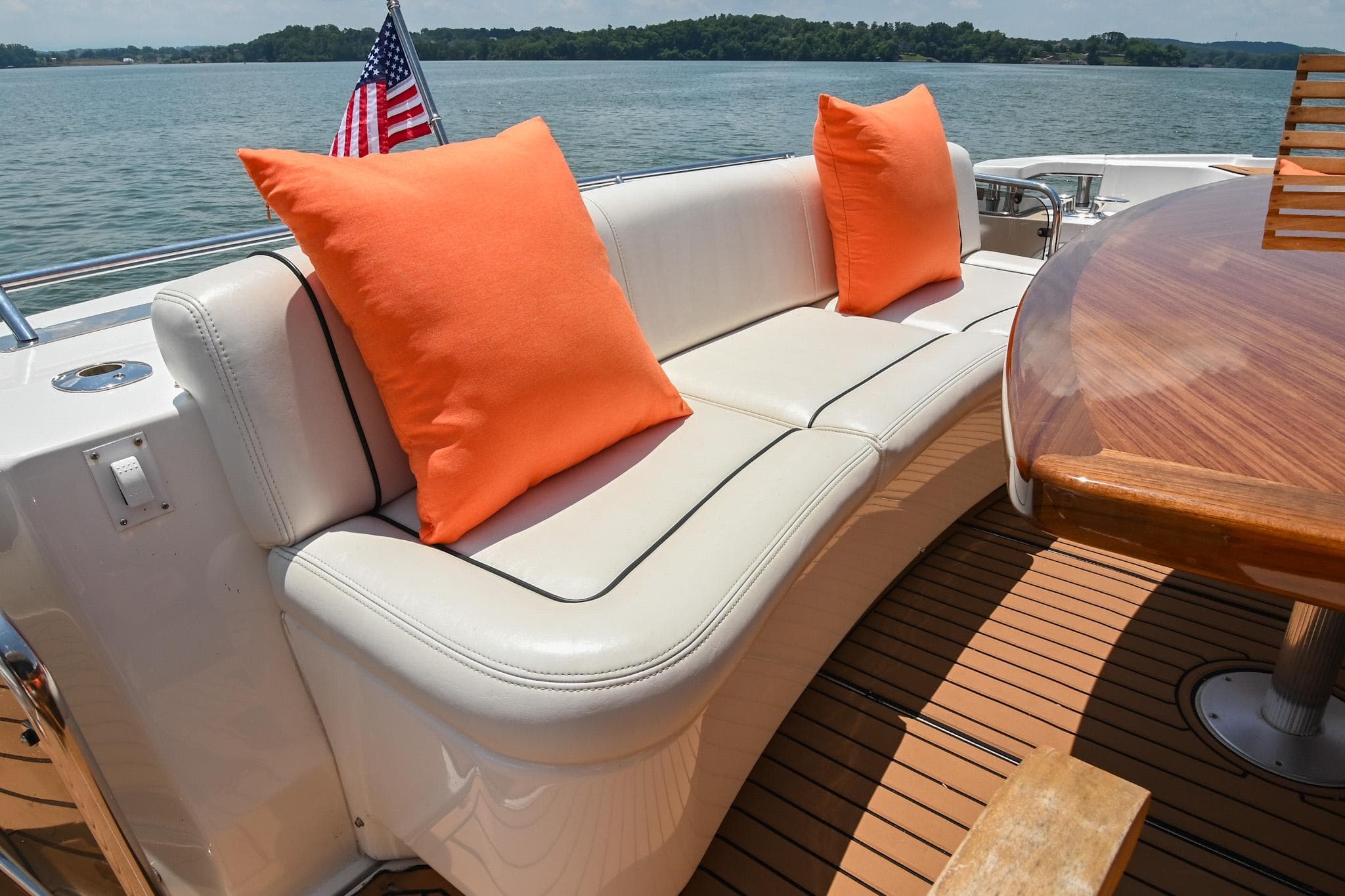 Luxurious 2007 Sea Ray 60 Sundancer yacht deck with white seating and orange cushions.