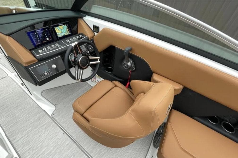 2026 Four Winns H6 boat cockpit with modern controls and tan seating.