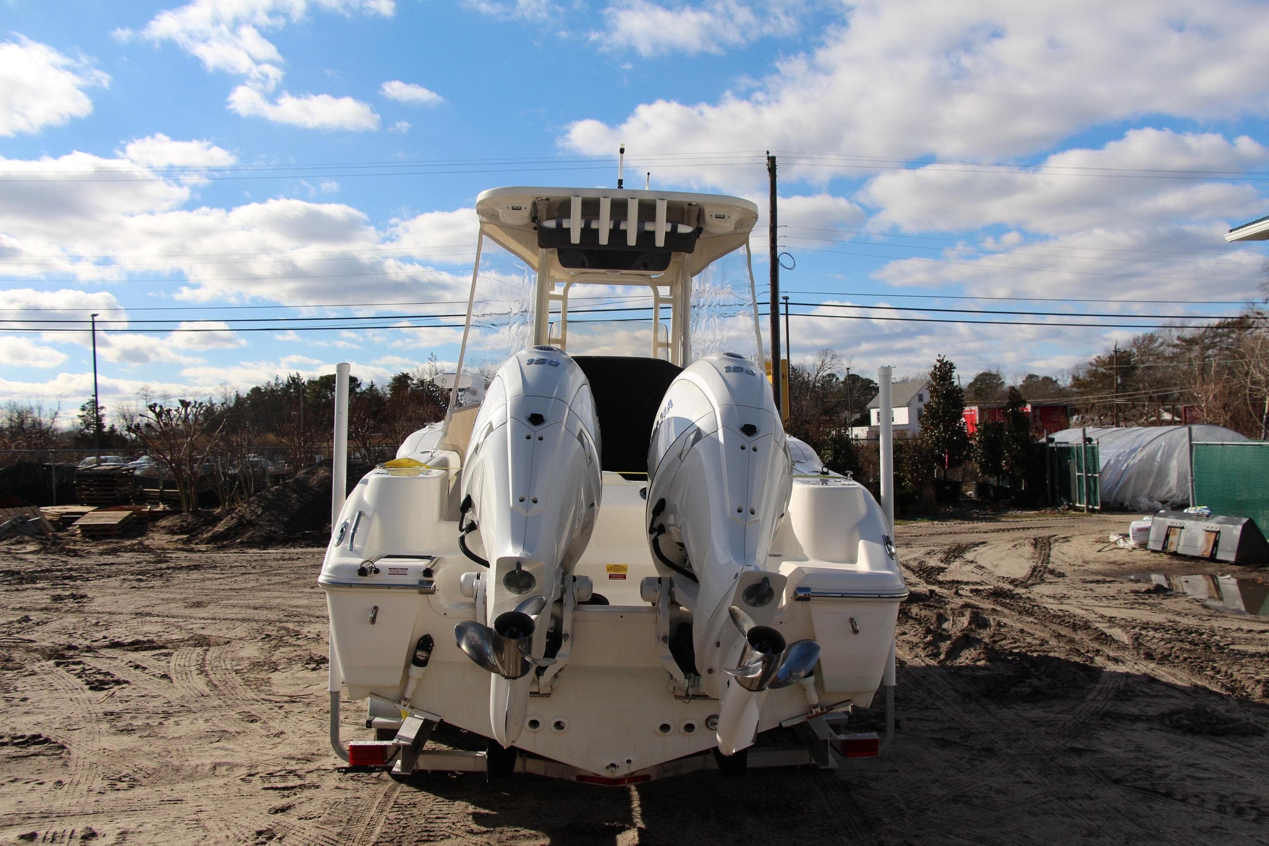 2024 Key West 244 Center Console boat with dual outboard engines on sandy terrain.