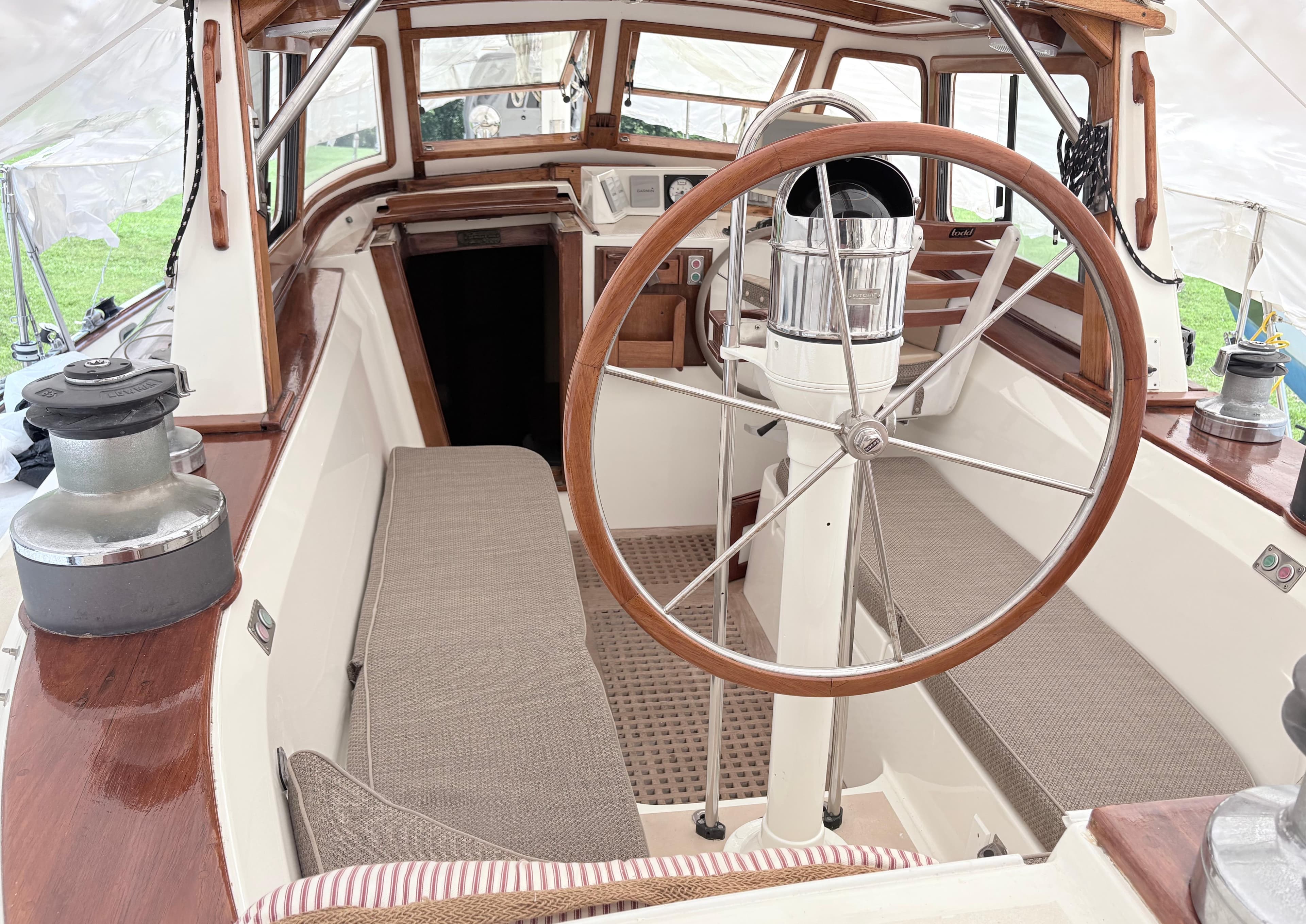 Cockpit of 1984 Shannon Aegean 51 sailboat with wooden wheel and seating.