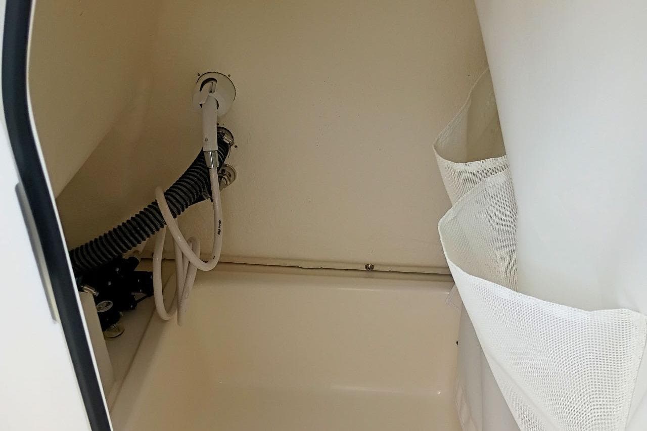 Interior view of 2027 Pioneer 202 Islander boat's storage compartment with hoses and netting.