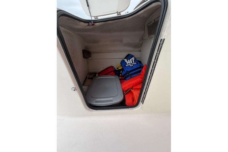 Storage compartment of 2000 Chaparral 232 Sunesta boat with life jackets and gear.