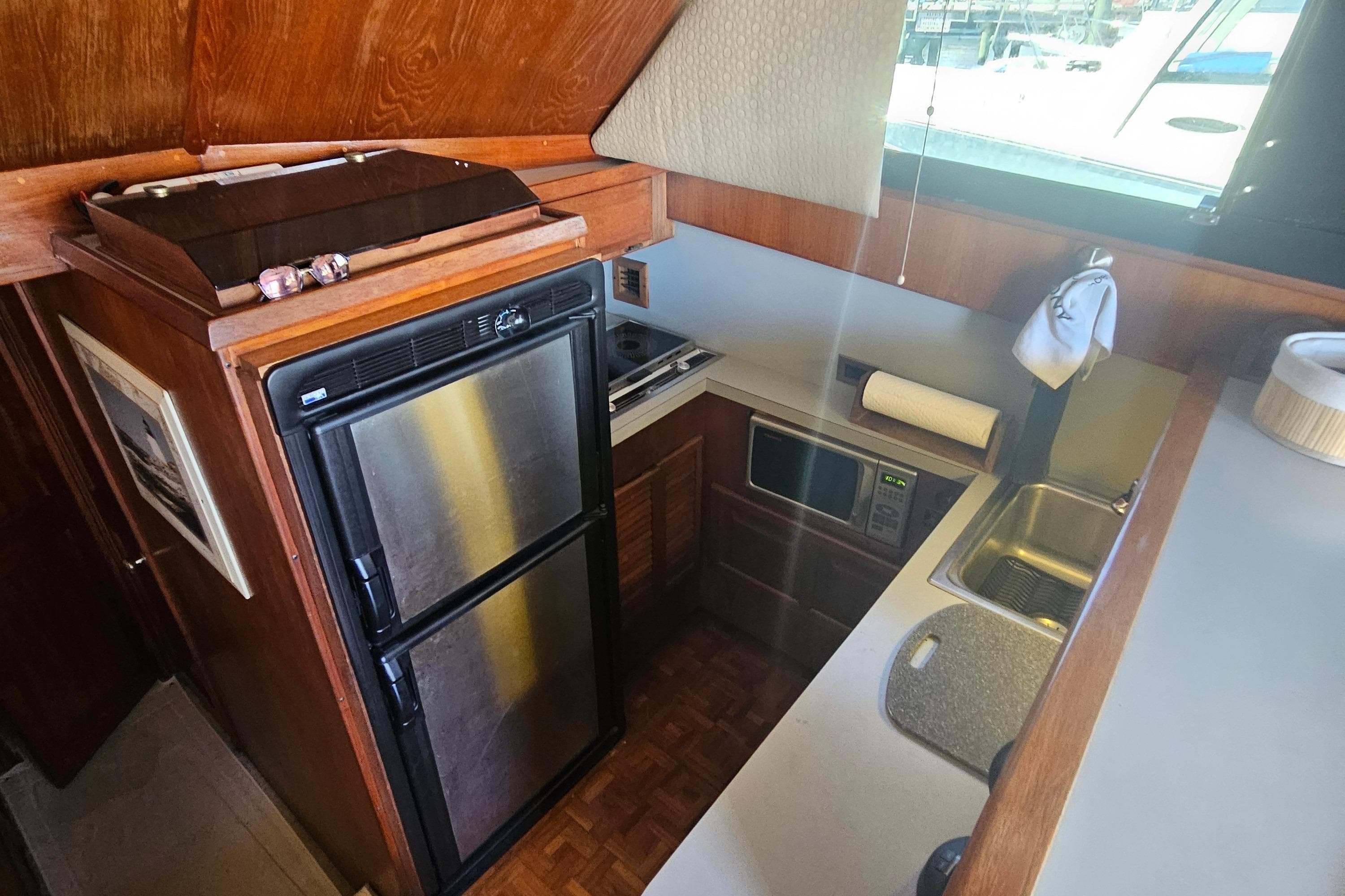 1986 Viking 35 Convertible yacht kitchen with stainless steel appliances and wooden cabinetry.