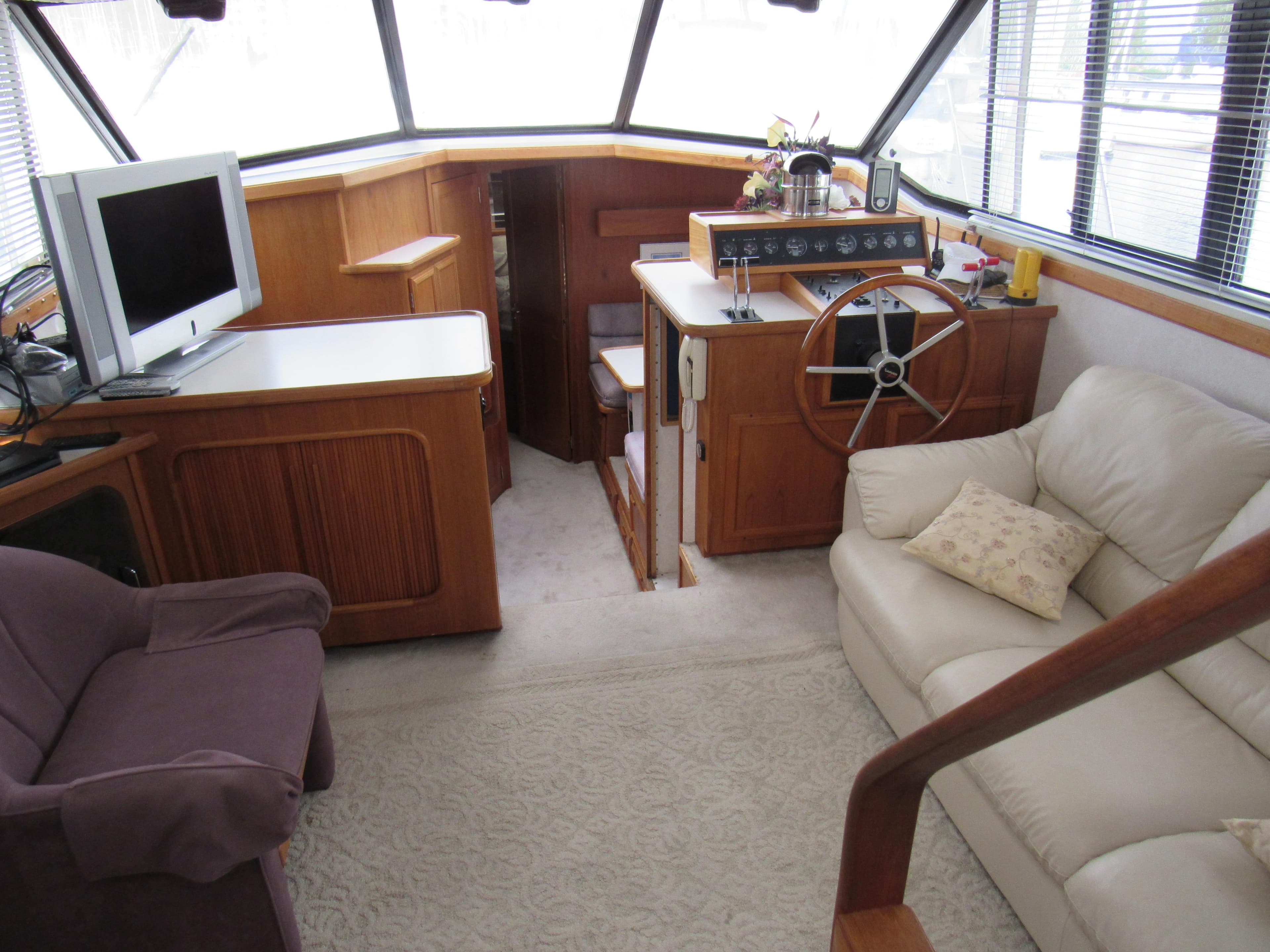 Interior of 1991 Carver 430 Cockpit Motor Yacht with cozy seating and helm station.