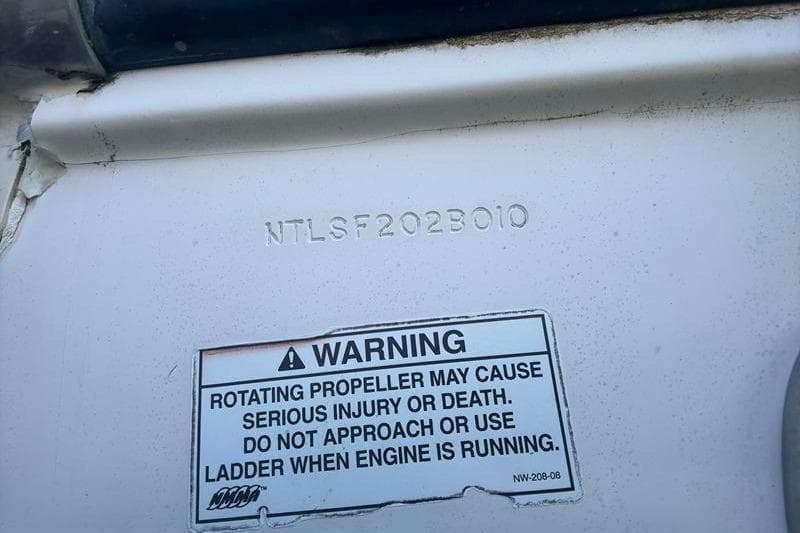 Warning label on 2010 Grady-White Chesapeake 290 boat, cautioning about rotating propeller danger.