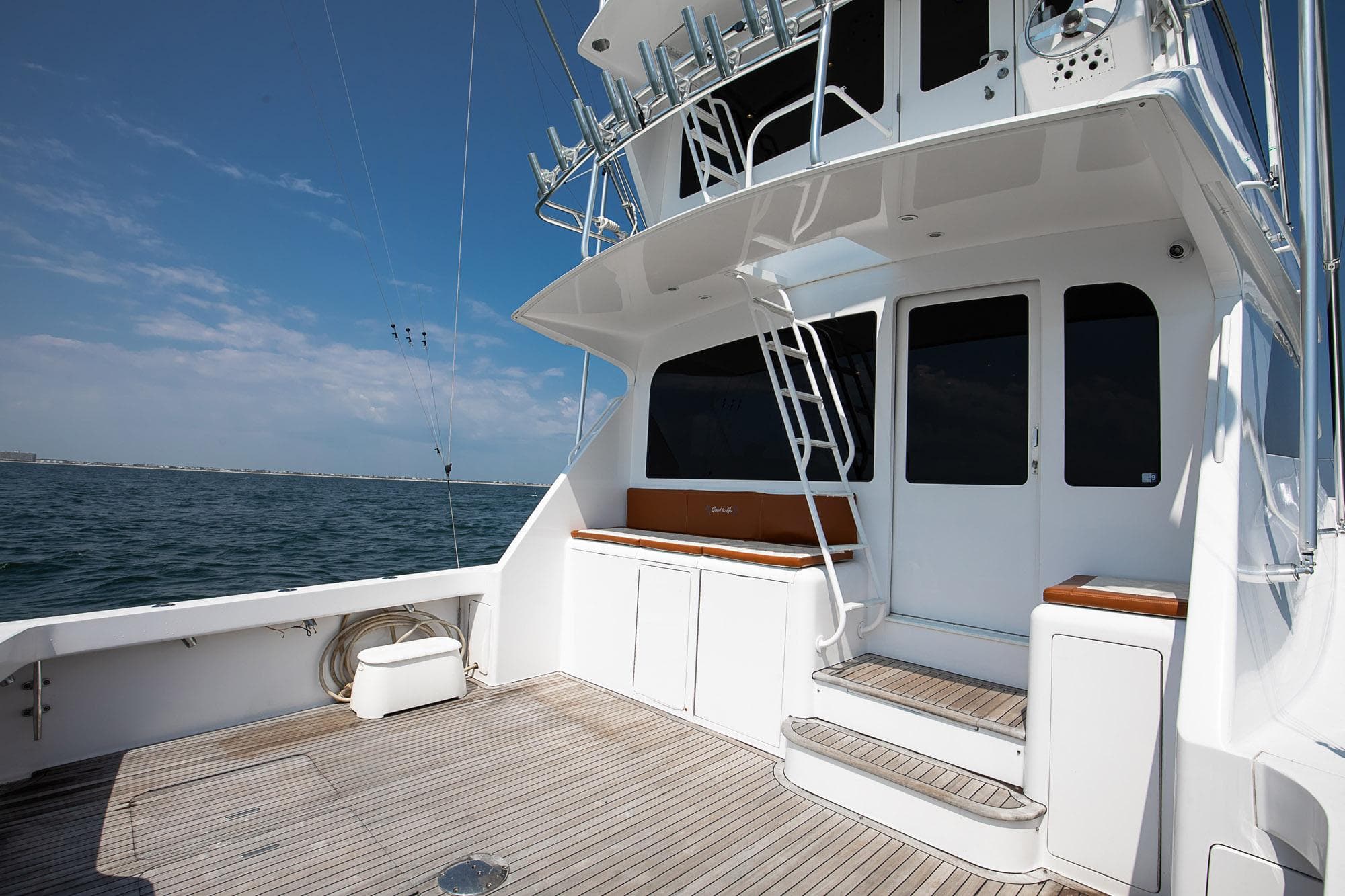 2002 Viking 61 yacht deck with stairs, ocean view, and clear sky.