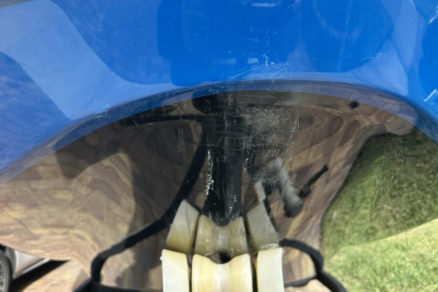 Close-up of a 2021 Scarab 215 boat hull with visible scratches.
