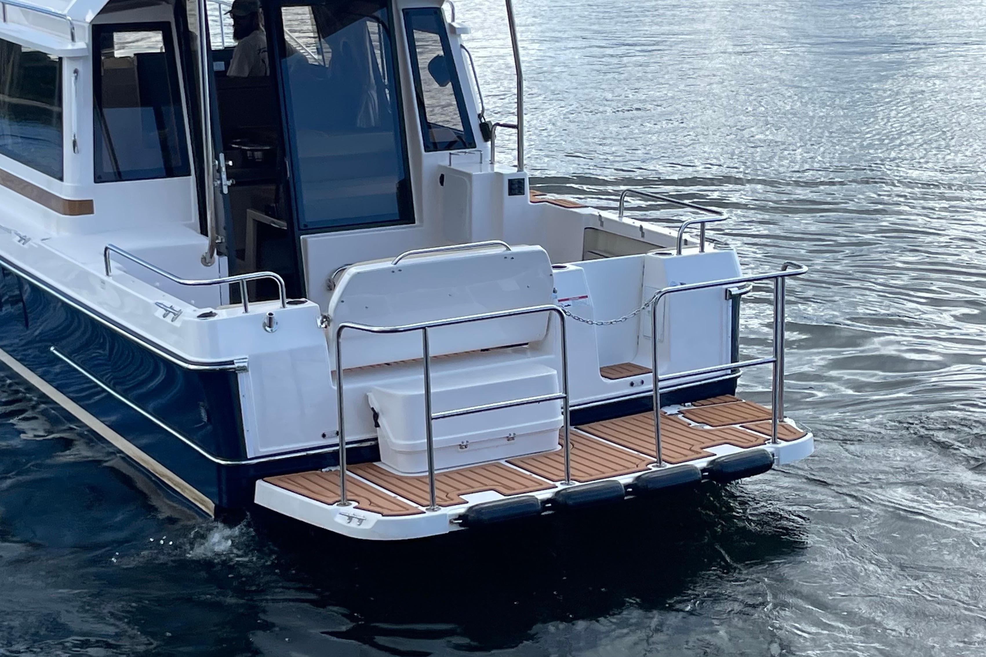 2026 Ranger Tugs R-29 S boat, rear view, on calm water.