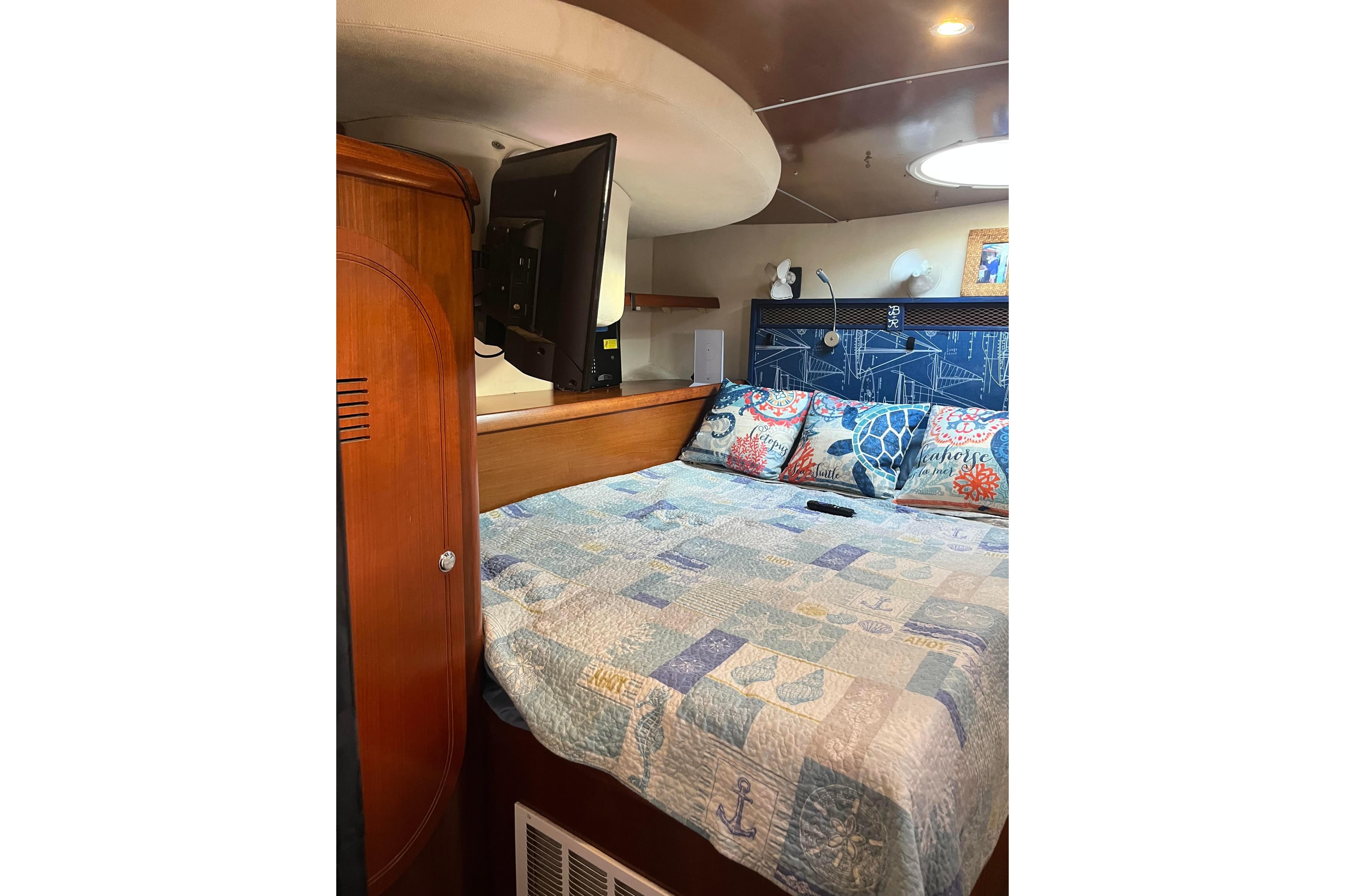 Cozy bedroom interior of 2000 Fountaine Pajot Belize 43 catamaran with nautical-themed decor.