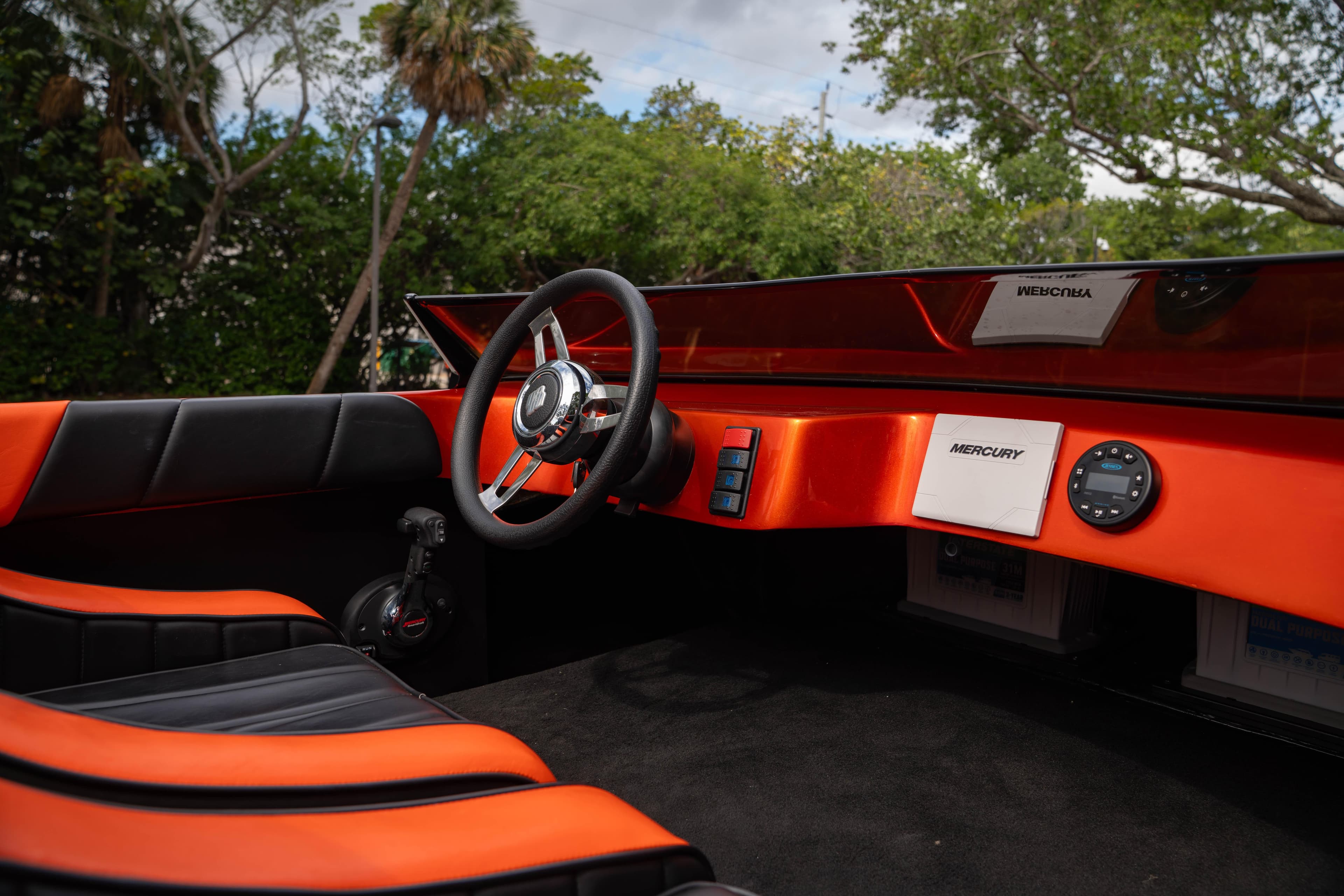 1984 Sleekcraft Aristocrat 20 boat interior with orange and black design, featuring a steering wheel.
