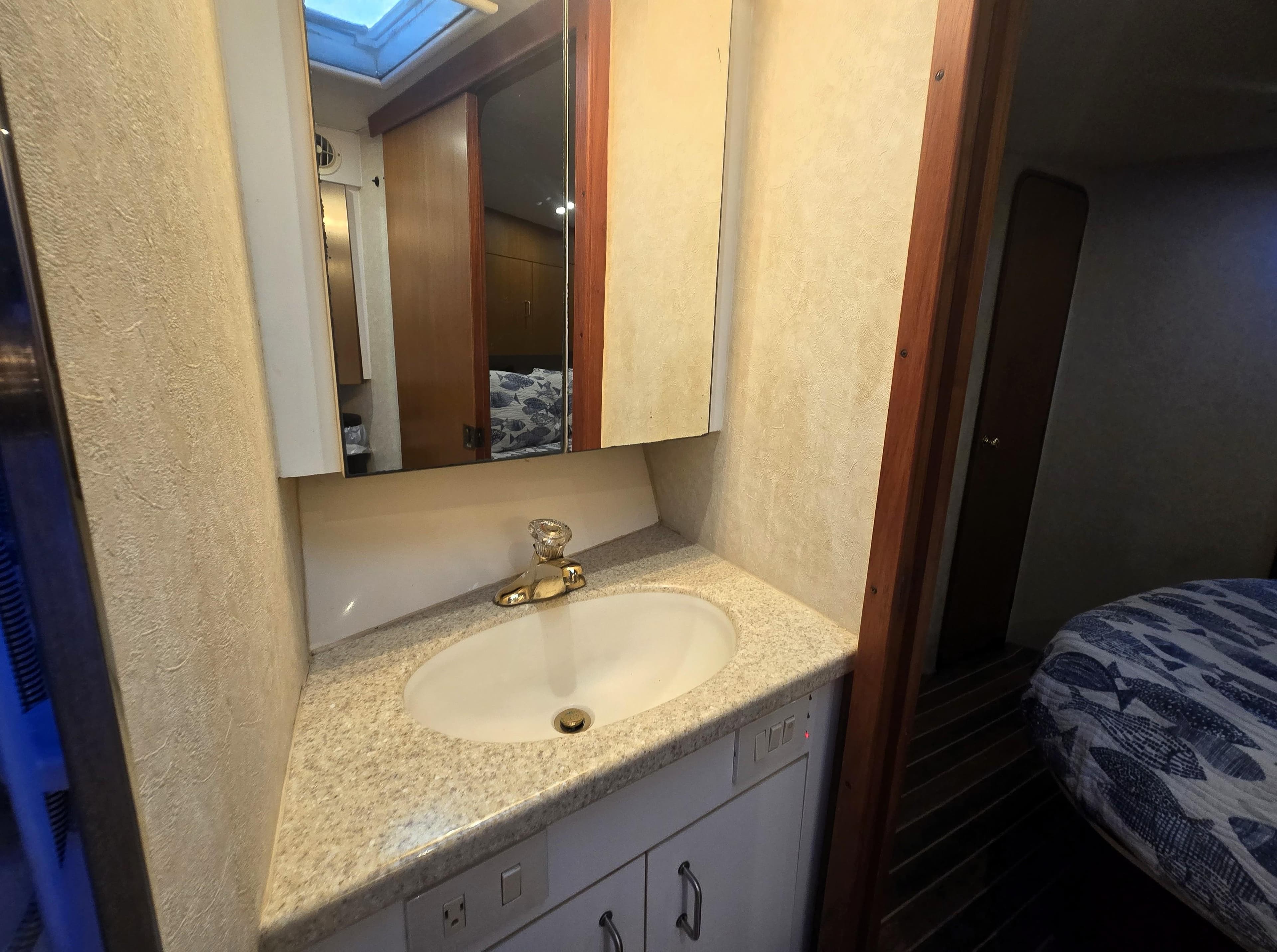 Bathroom vanity in 2001 Ocean Yachts 43 Super Sport, featuring a sink and mirror.