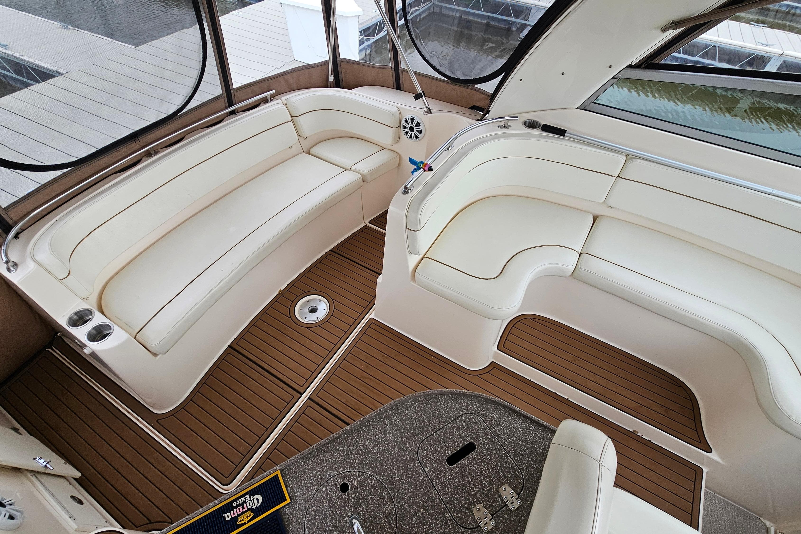 2004 Rinker Fiesta Vee 312 boat interior with cream seating and wood flooring.