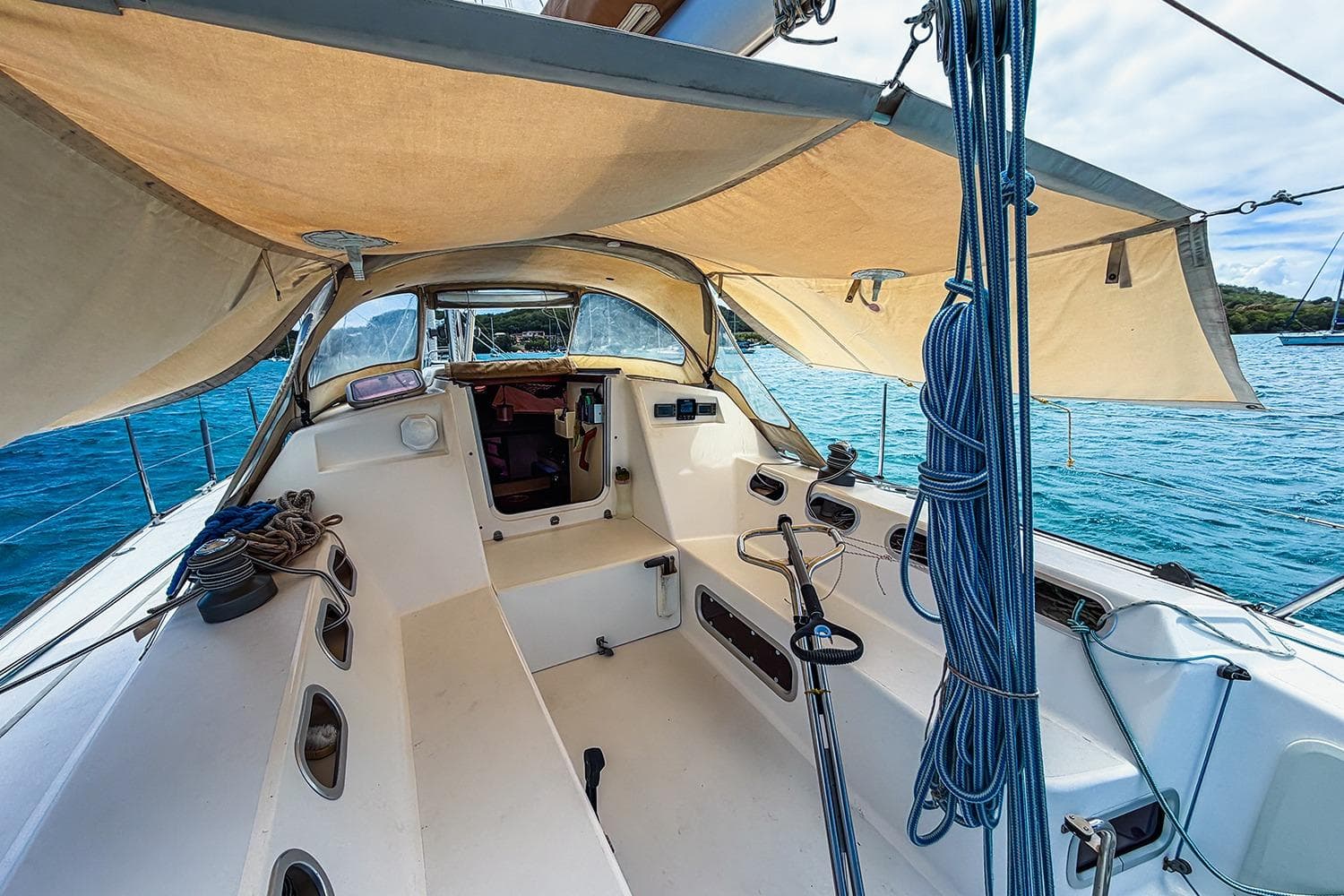 Cockpit of 2006 RM Yachts 1050 sailboat with canopy, ropes, and ocean view.