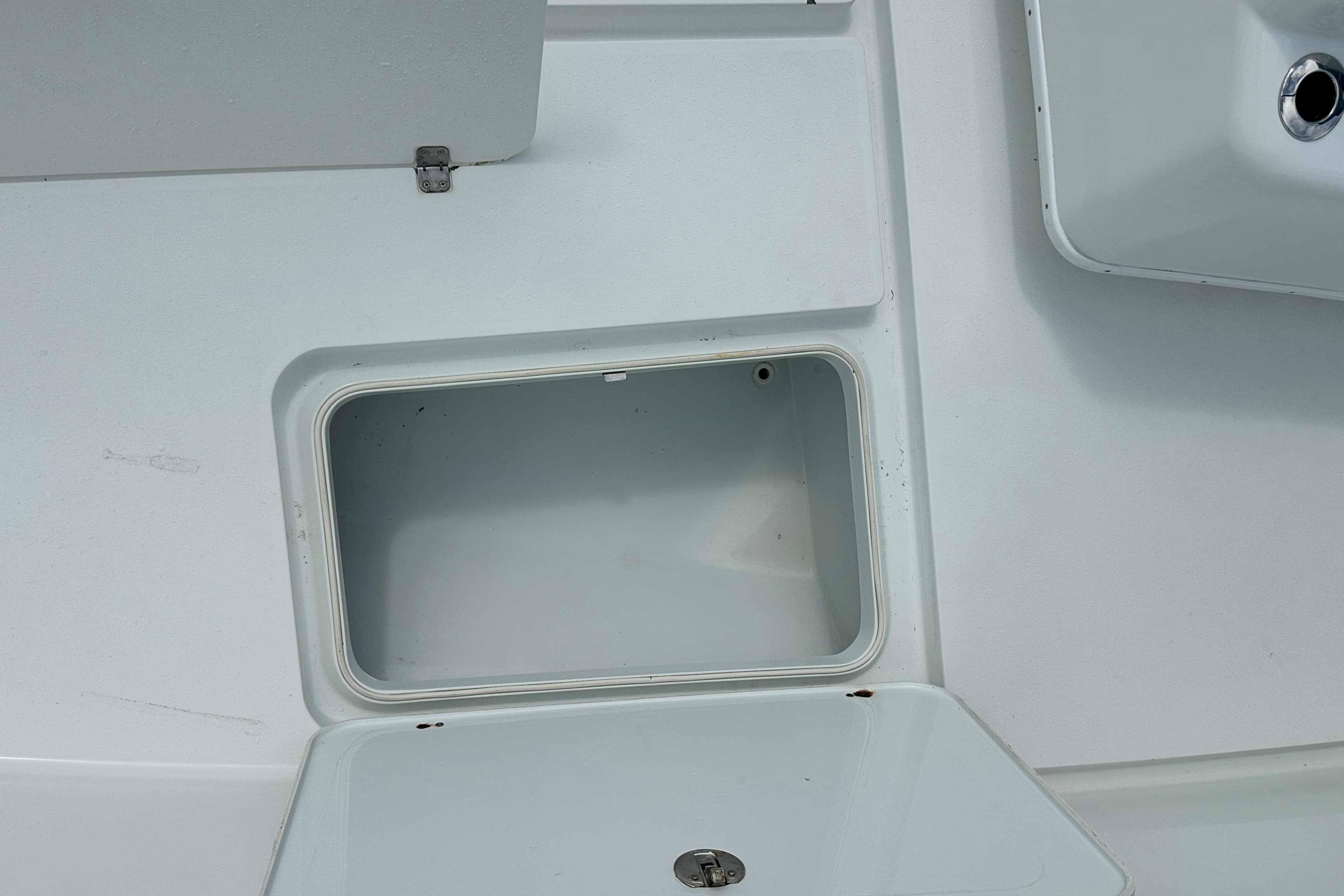 Storage compartment on a 2009 Yellowfin 42 Offshore boat, featuring a clean, white interior.