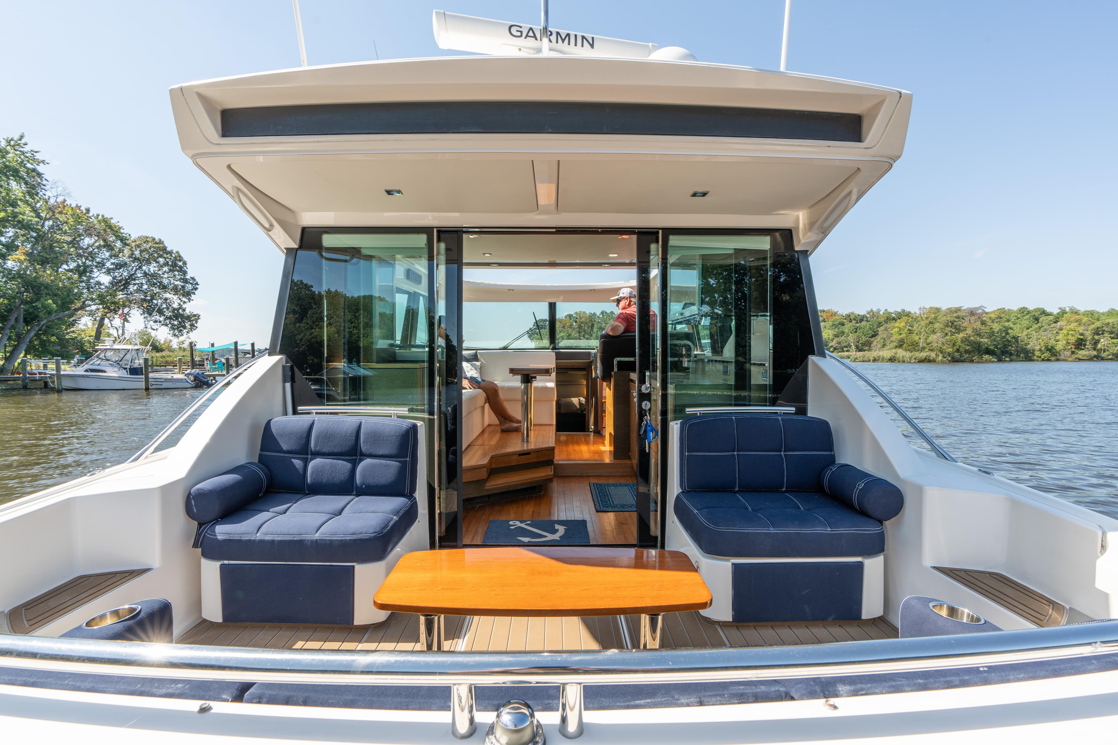2015 Tiara Yachts C44 Coupe with elegant seating, docked on a serene lake.