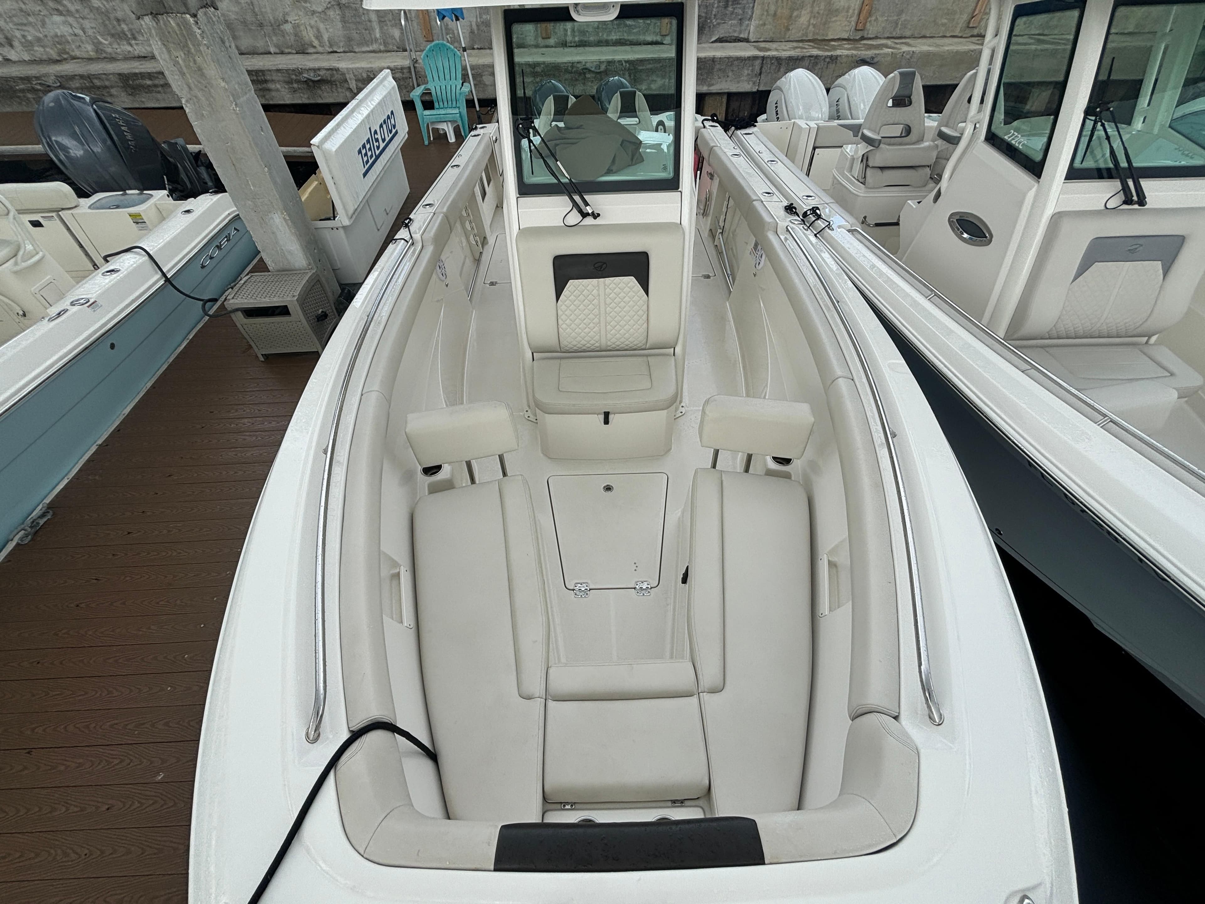 2023 Sailfish 272 CC boat interior with white seating and console, docked at marina.