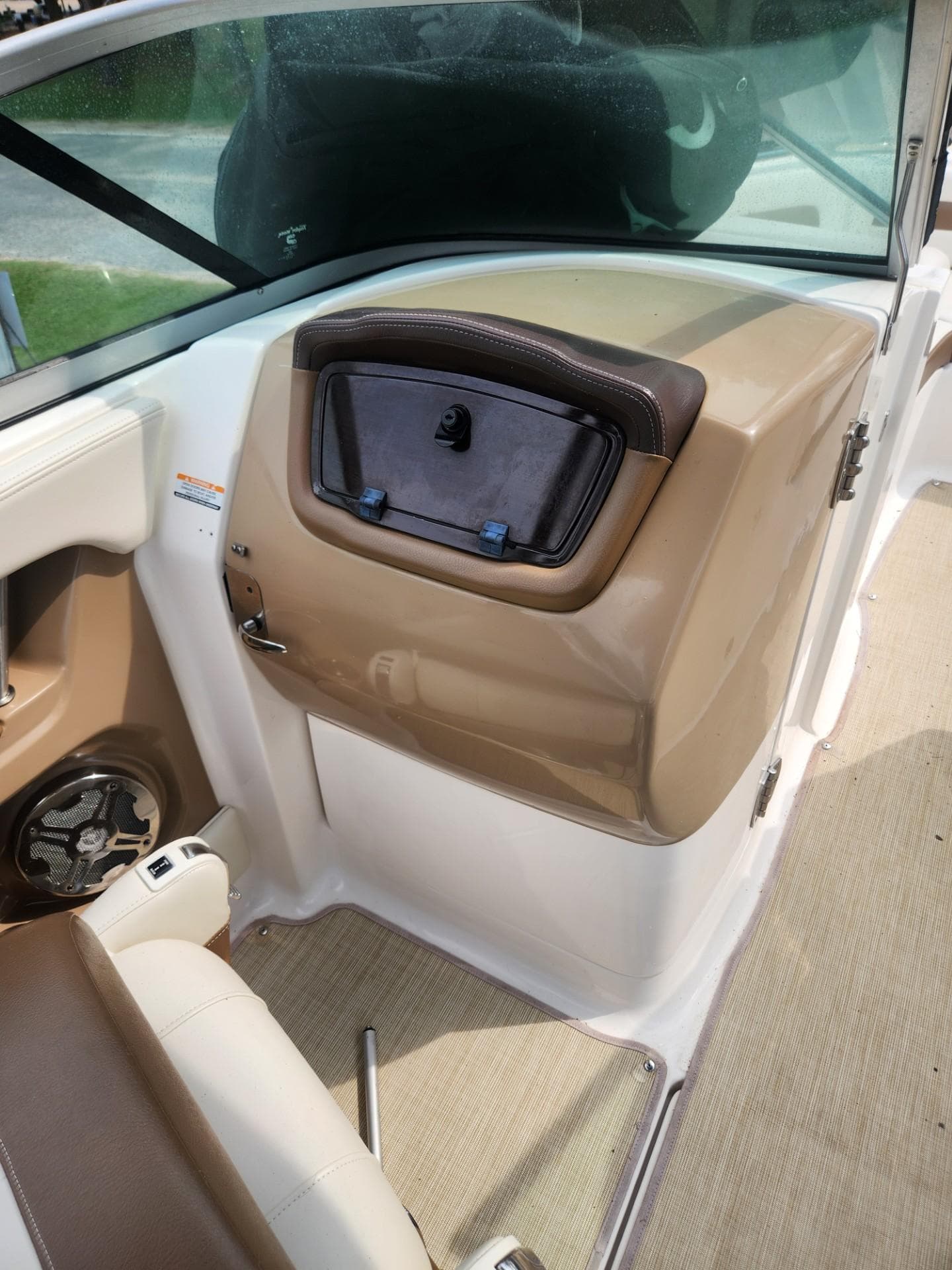 2016 Chaparral 246 SSi boat interior with beige and white seating, storage compartment, and speaker.