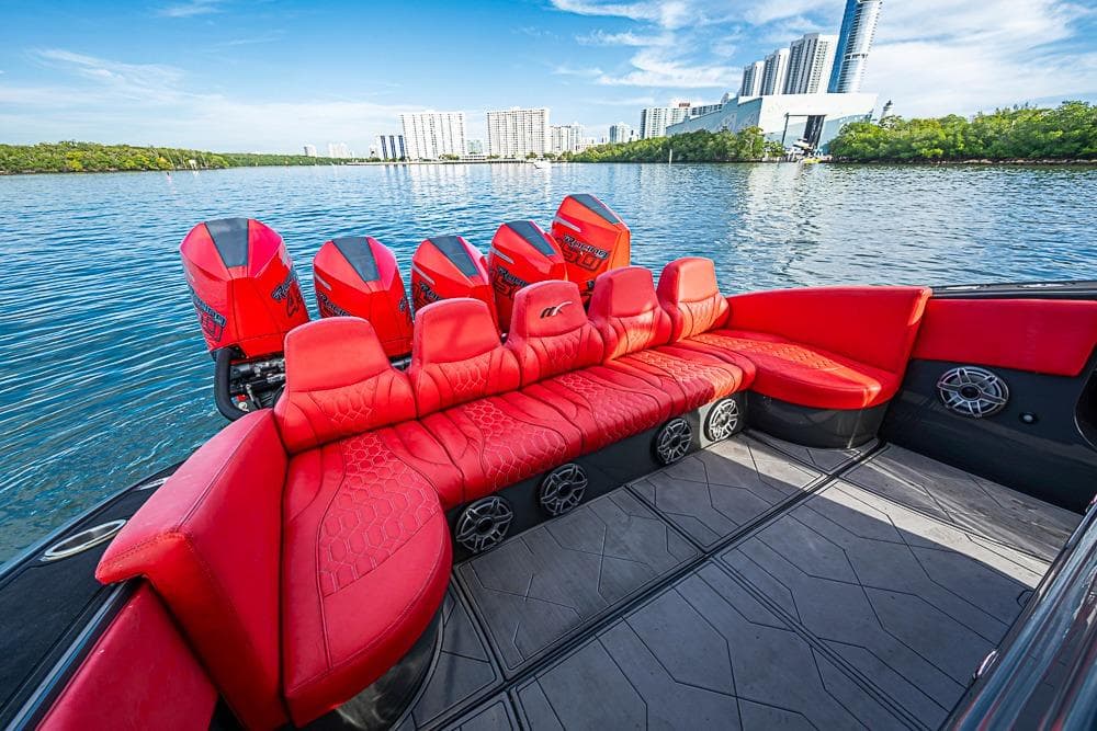Red interior of 2021 Midnight Express 43 Solstice boat with multiple engines on a scenic waterway.