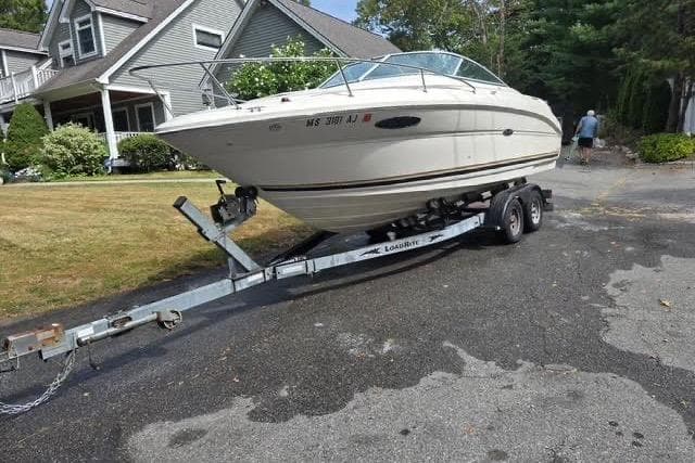 2004 Sea Ray 215 Weekender boat on trailer in residential driveway.