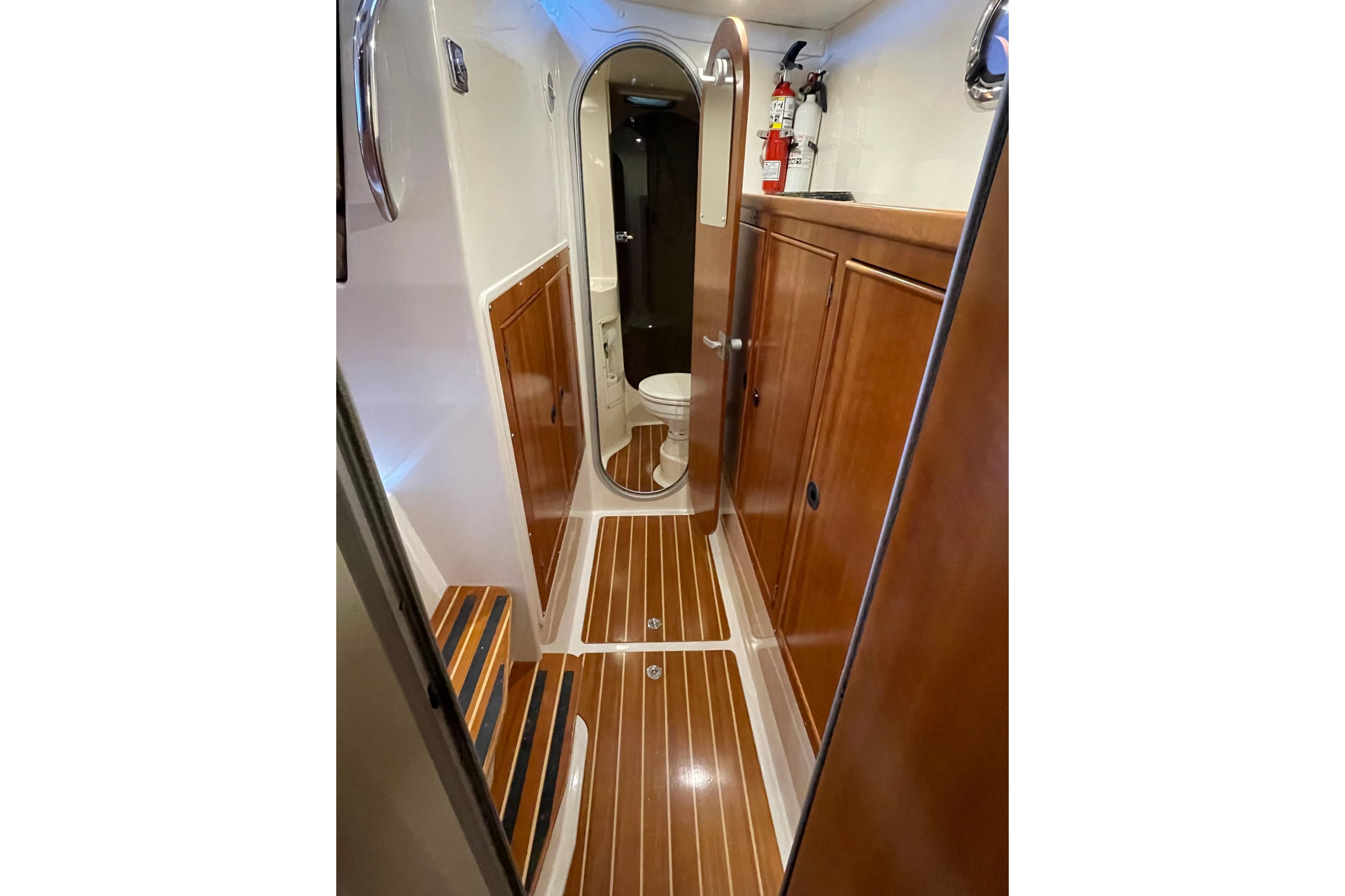 2006 PDQ 34 Power Catamaran interior with wood paneling and compact bathroom.