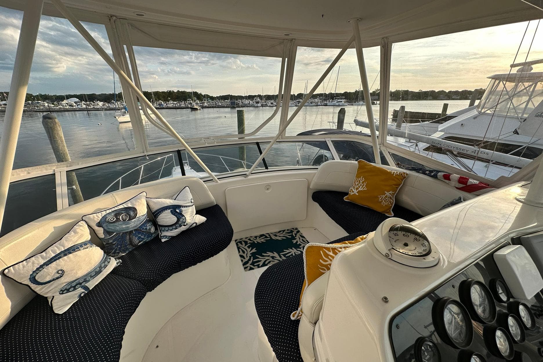 Cozy seating area on a 2001 Silverton 42 Convertible yacht, overlooking a serene marina.