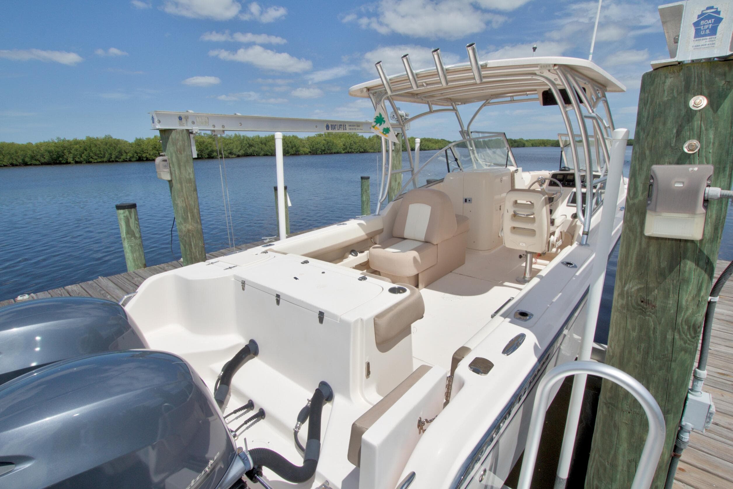 2013 Grady-White Freedom 275 boat docked by a serene waterfront under a clear sky.