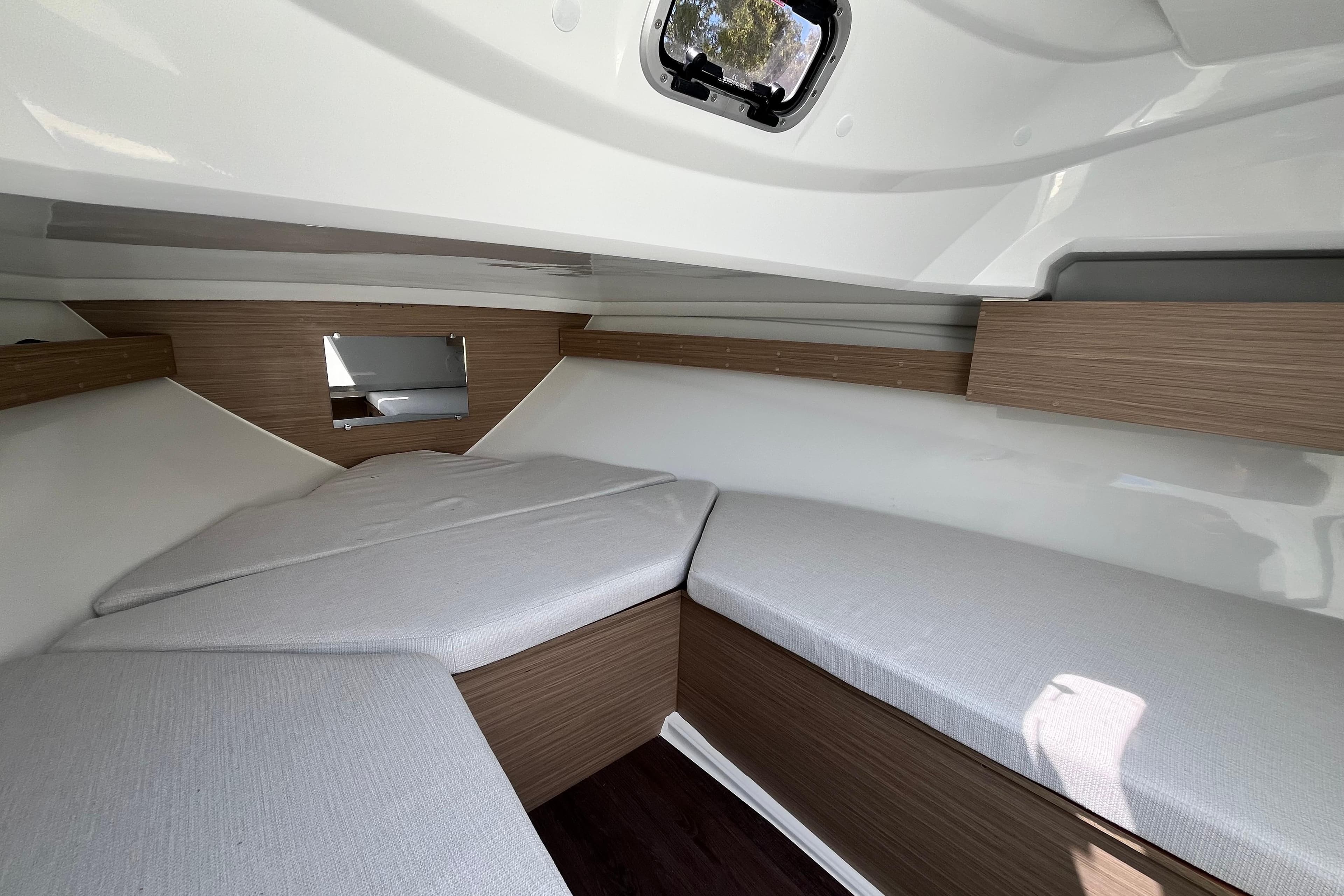 Interior cabin of 2026 Jeanneau Cap Camarat 6.5 WA, featuring cozy seating and modern design.
