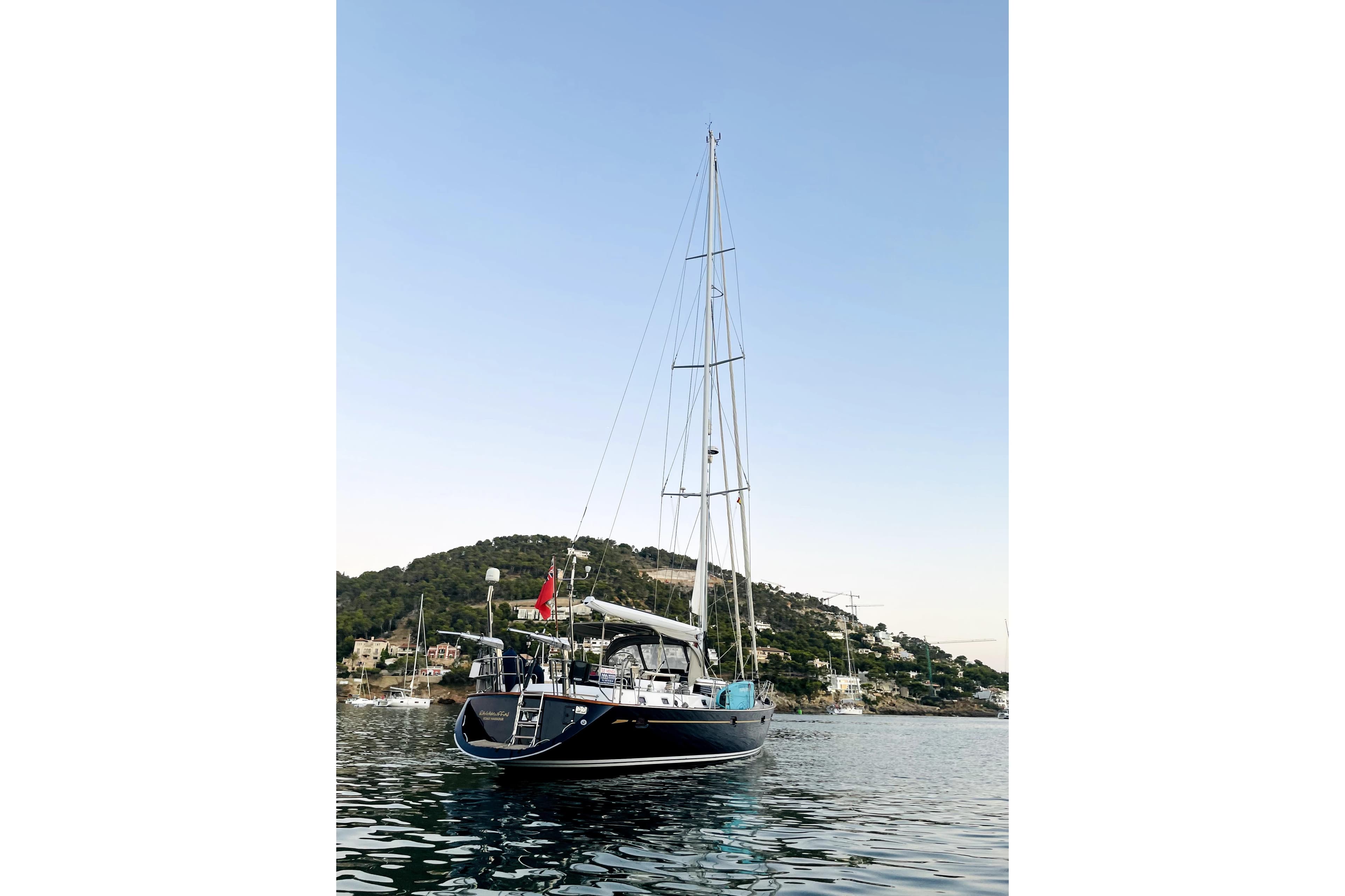 Sailing yacht Oyster 56, 2003 model, anchored in scenic coastal waters.