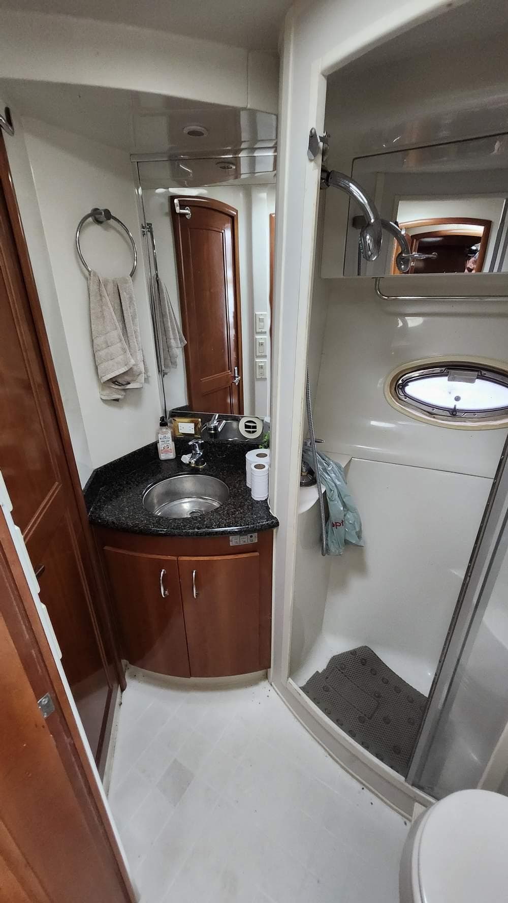 2005 Carver 420 Mariner bathroom with sink, shower, and wooden cabinetry.