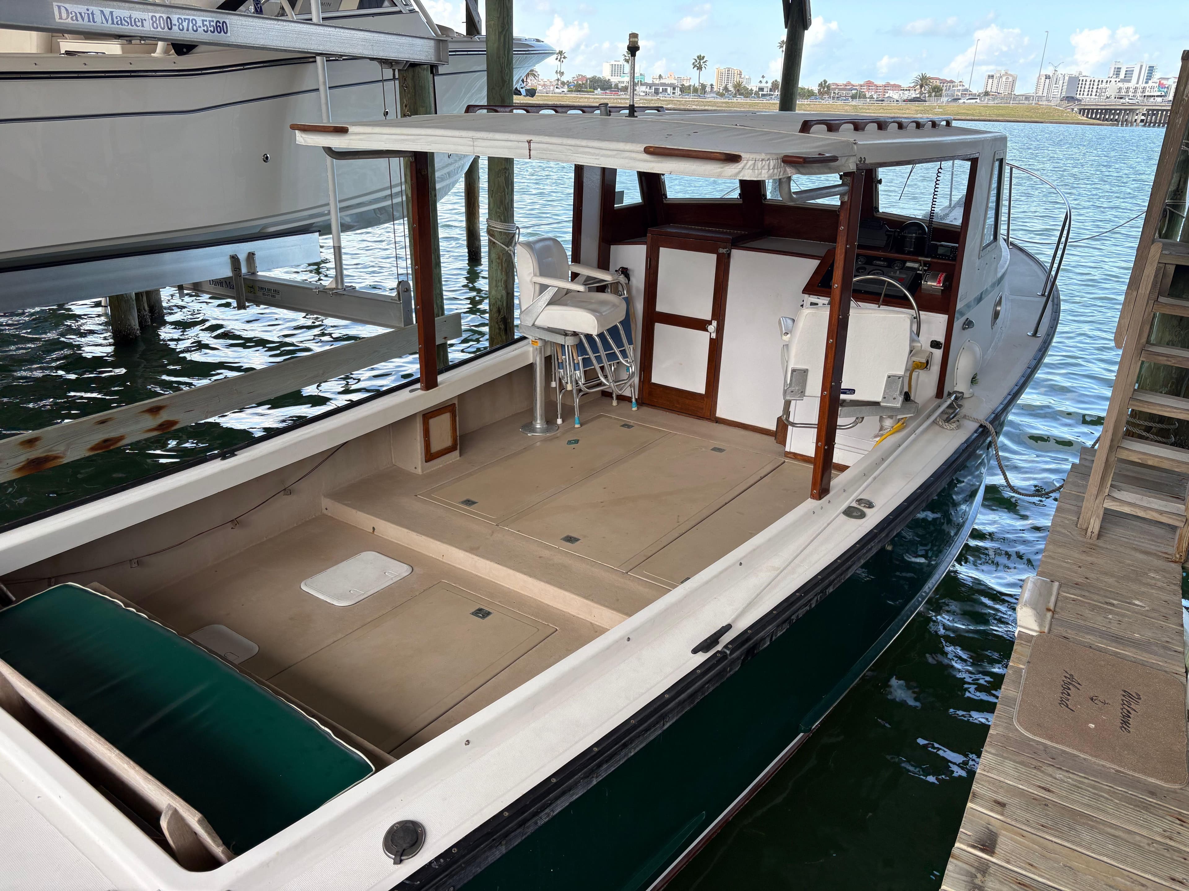 1988 Ellis Down East boat docked, featuring spacious deck and canopy.