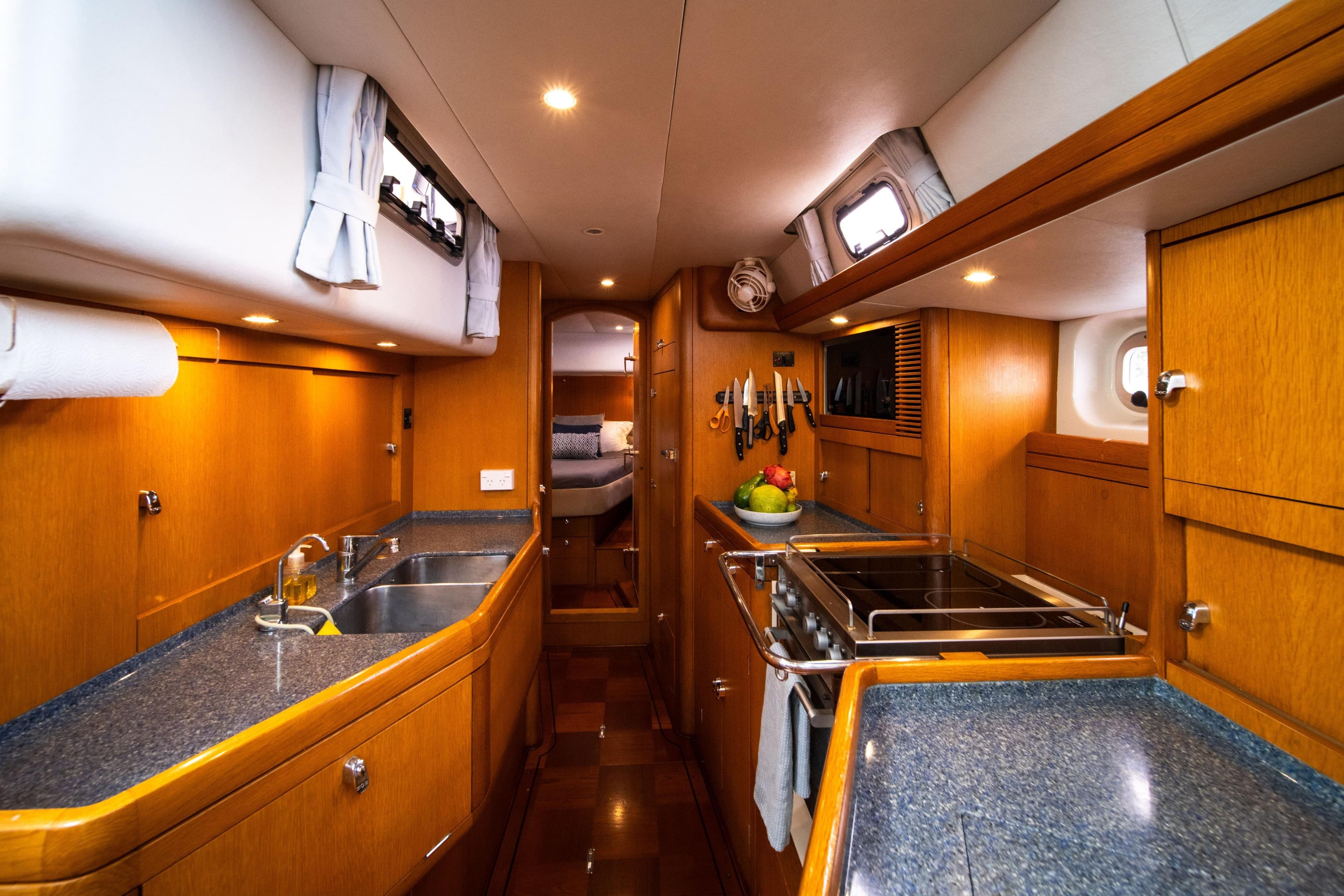 Luxurious 2004 Oyster 56 yacht kitchen with wood cabinetry and modern appliances.