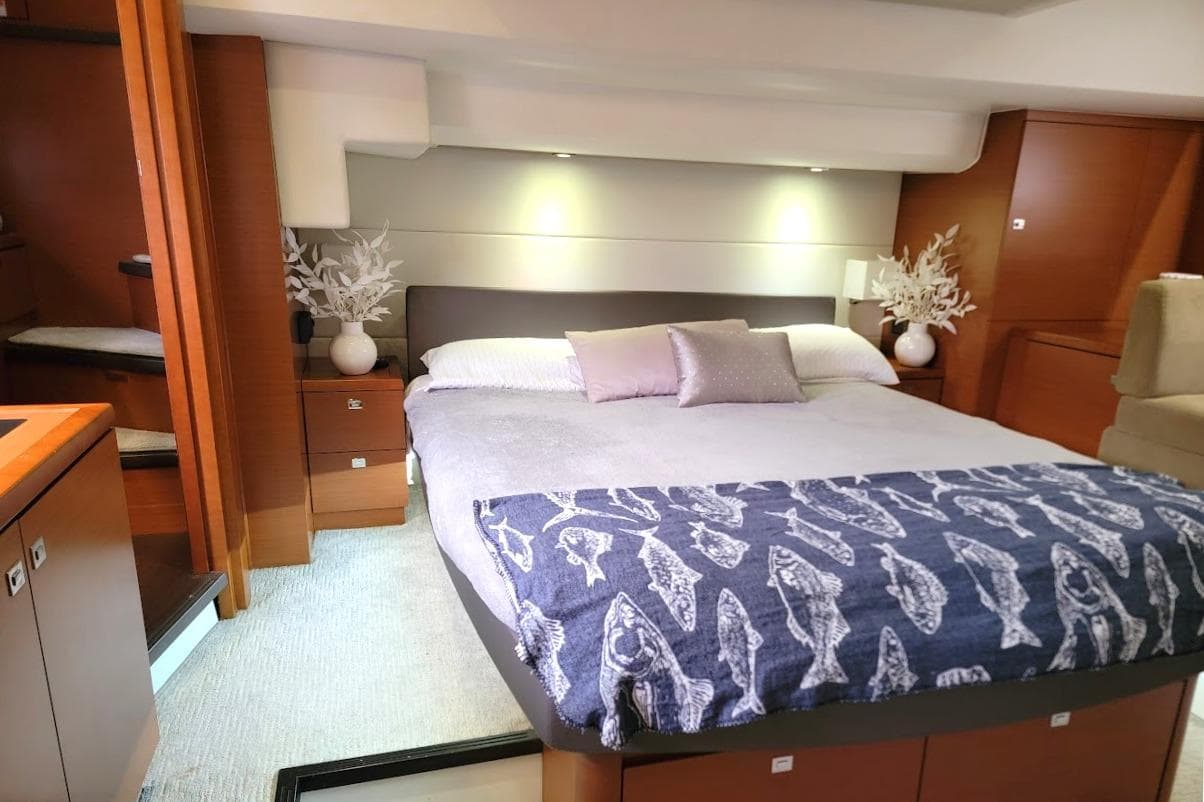 Luxurious bedroom interior of 2014 Prestige 550 yacht with elegant decor and cozy bedding.