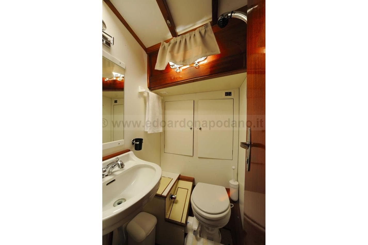 1964 Sangermani Yawl bathroom with sink, toilet, and wooden accents.