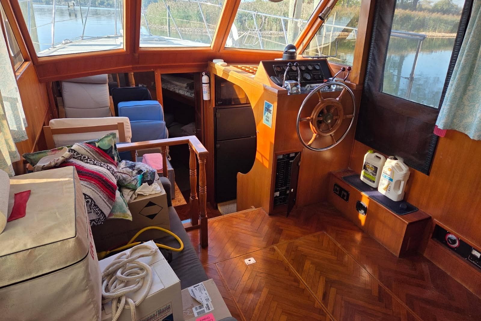 1988 Novamarine 36 Heritage East Trawler interior with wooden helm, seating, and nautical equipment.