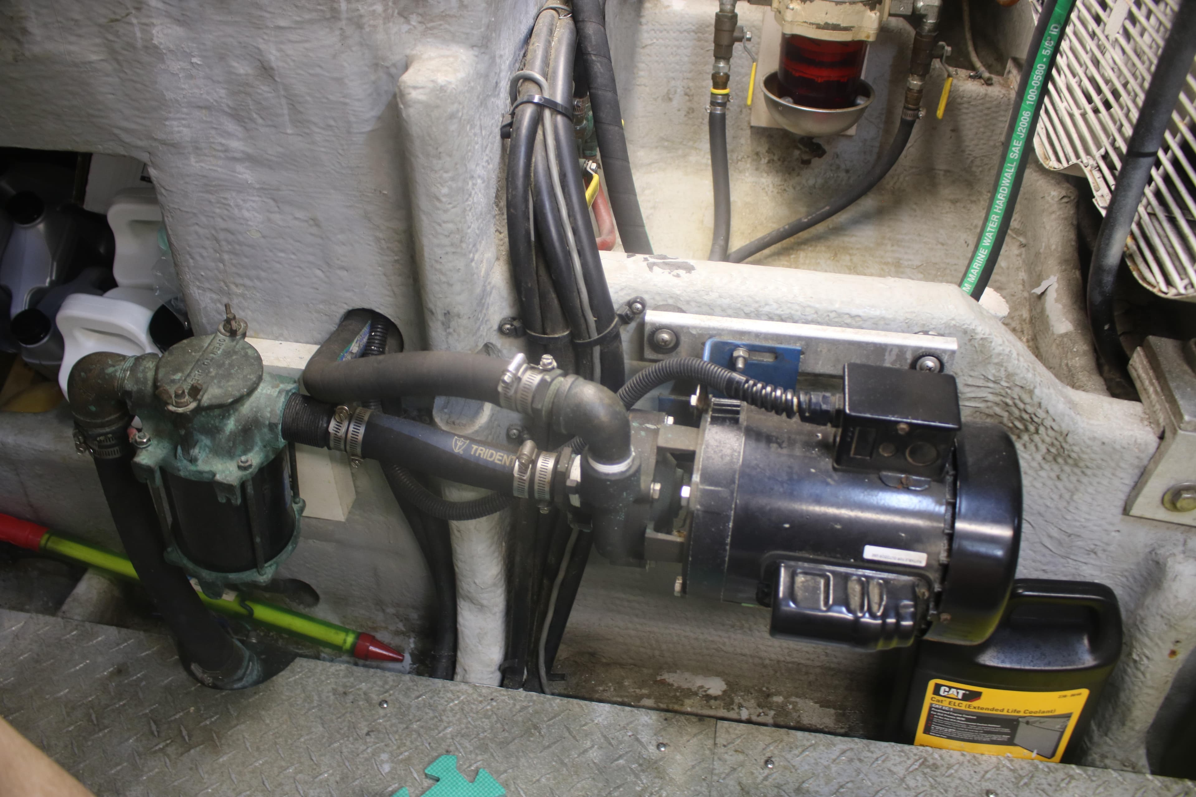 Engine room of 1998 Mainship 47 Motor Yacht showing mechanical components and hoses.
