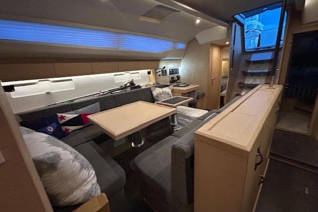 Luxurious interior of a 2016 Jeanneau 54 yacht with modern seating and dining area.