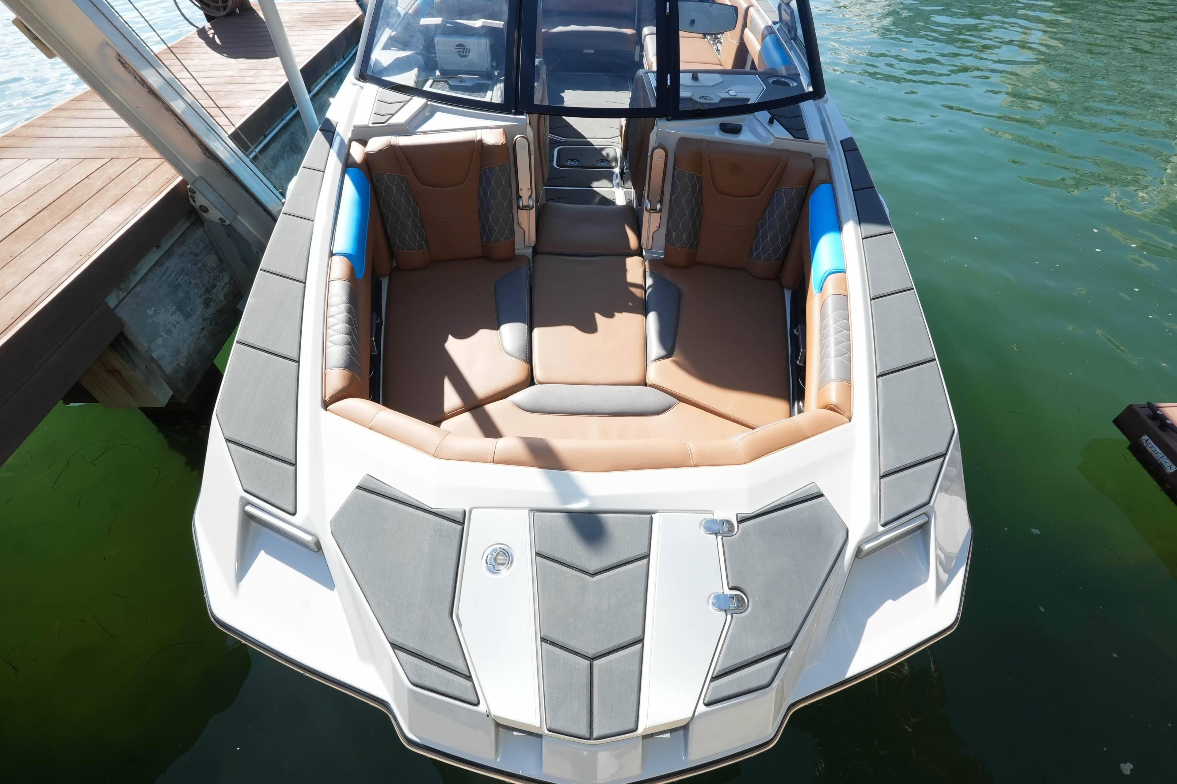 2020 Malibu M240 boat with luxurious seating, docked on clear water.