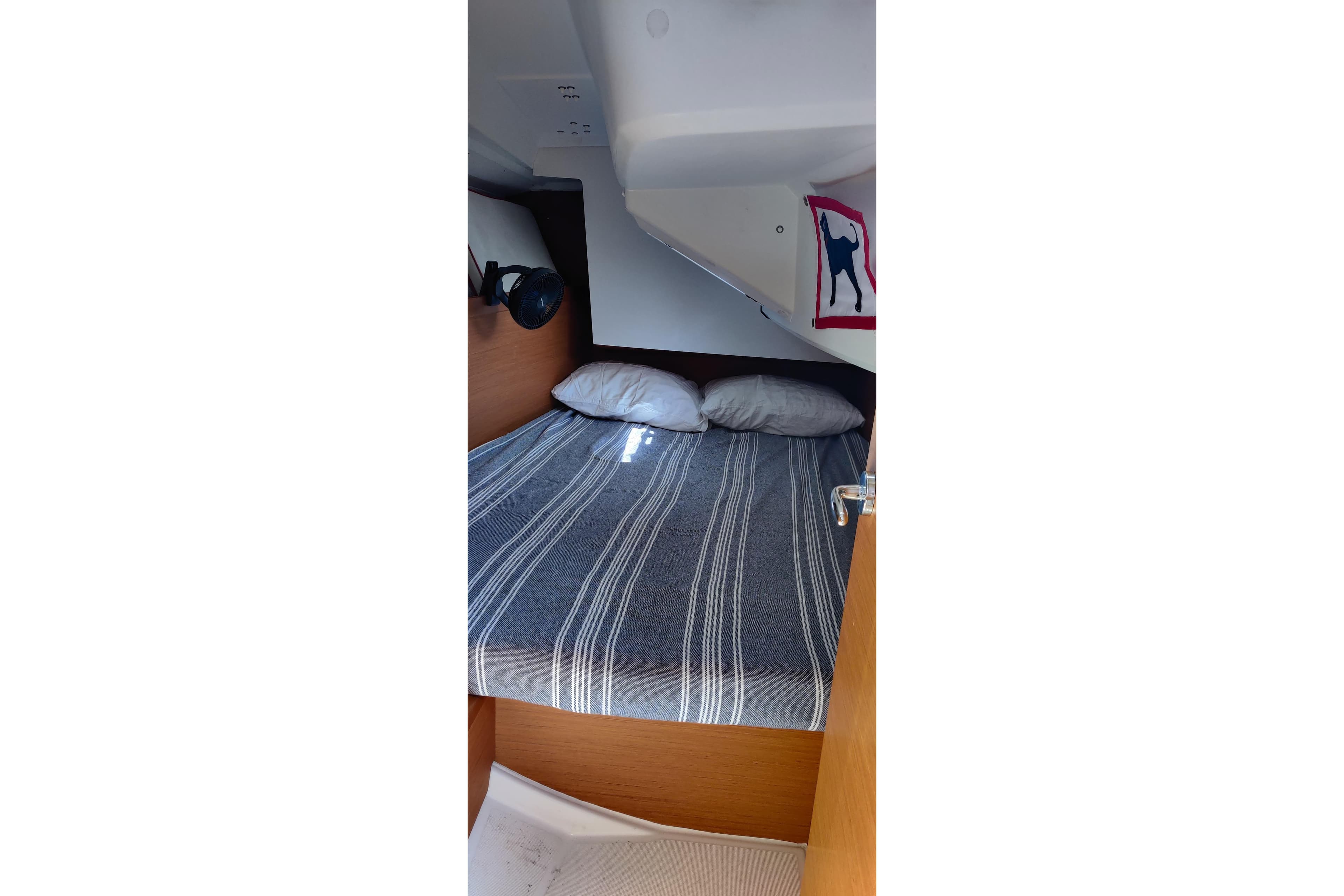Cozy cabin interior of 2016 Jeanneau Sun Odyssey 349 sailboat with striped bedding.