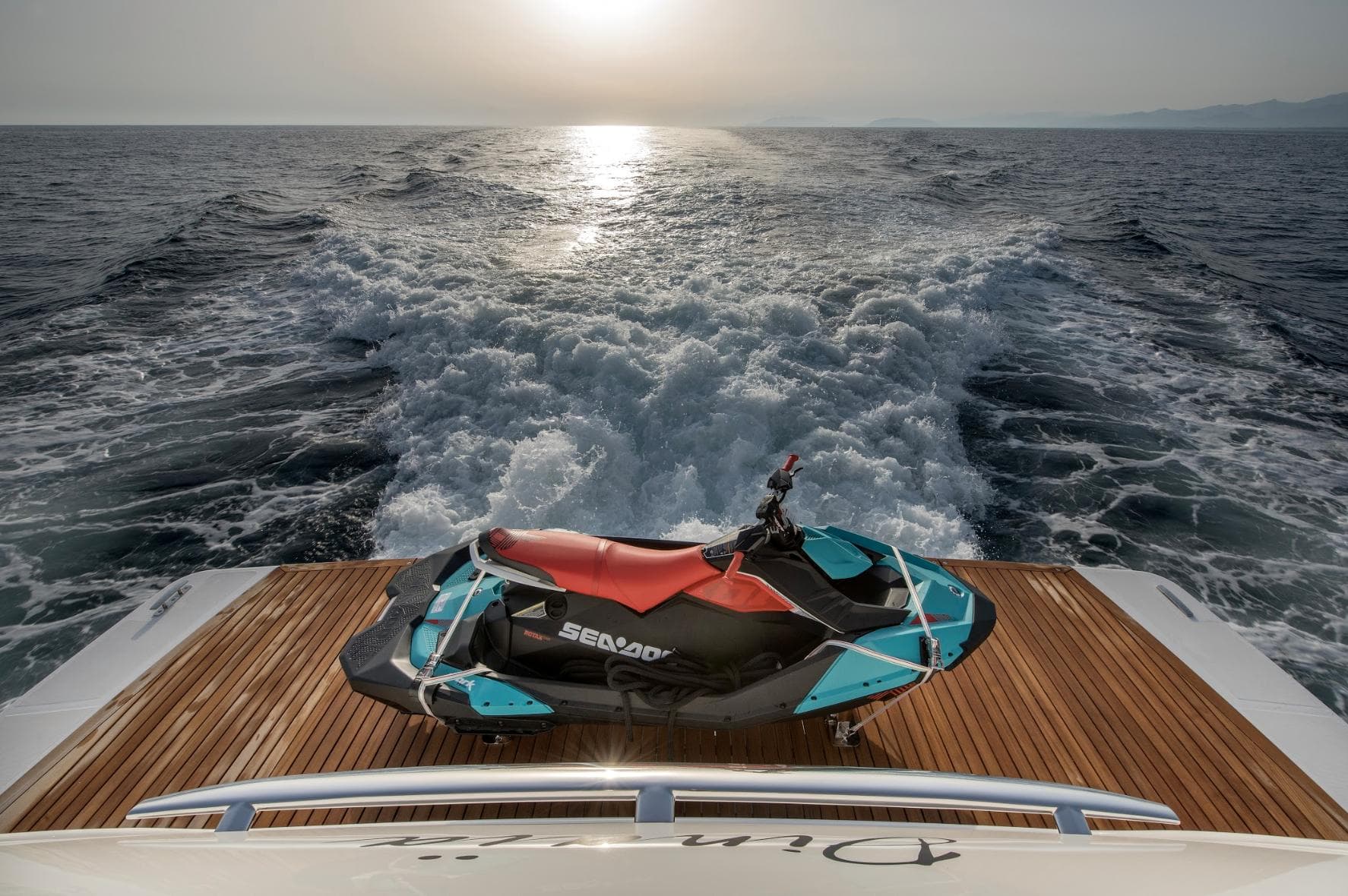 Sanlorenzo SL106 yacht with Sea-Doo jet ski on deck, cruising at sunset, 2018 model.