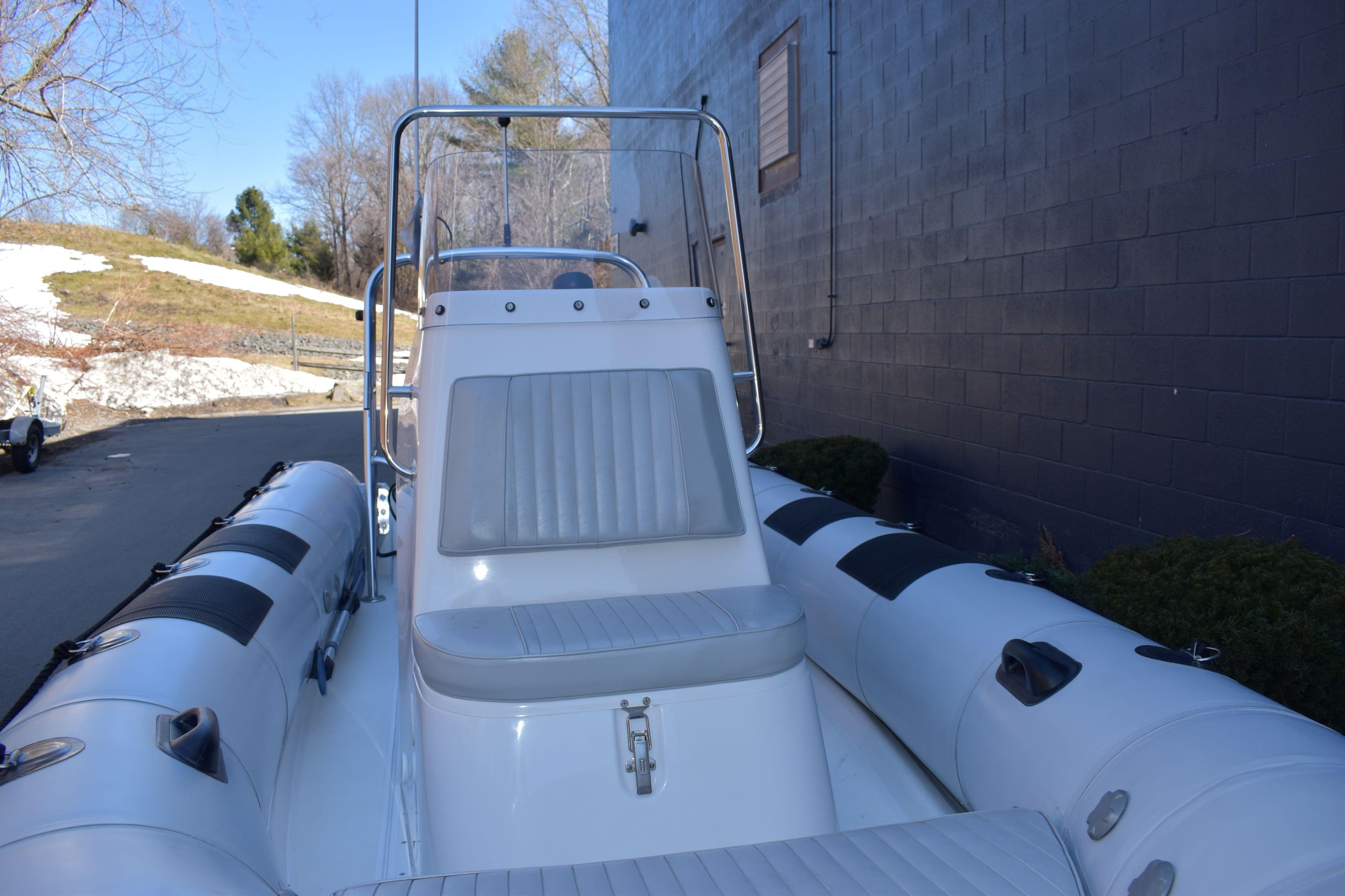 2020 Ribcraft 5.85 inflatable boat with seating, docked near a building.
