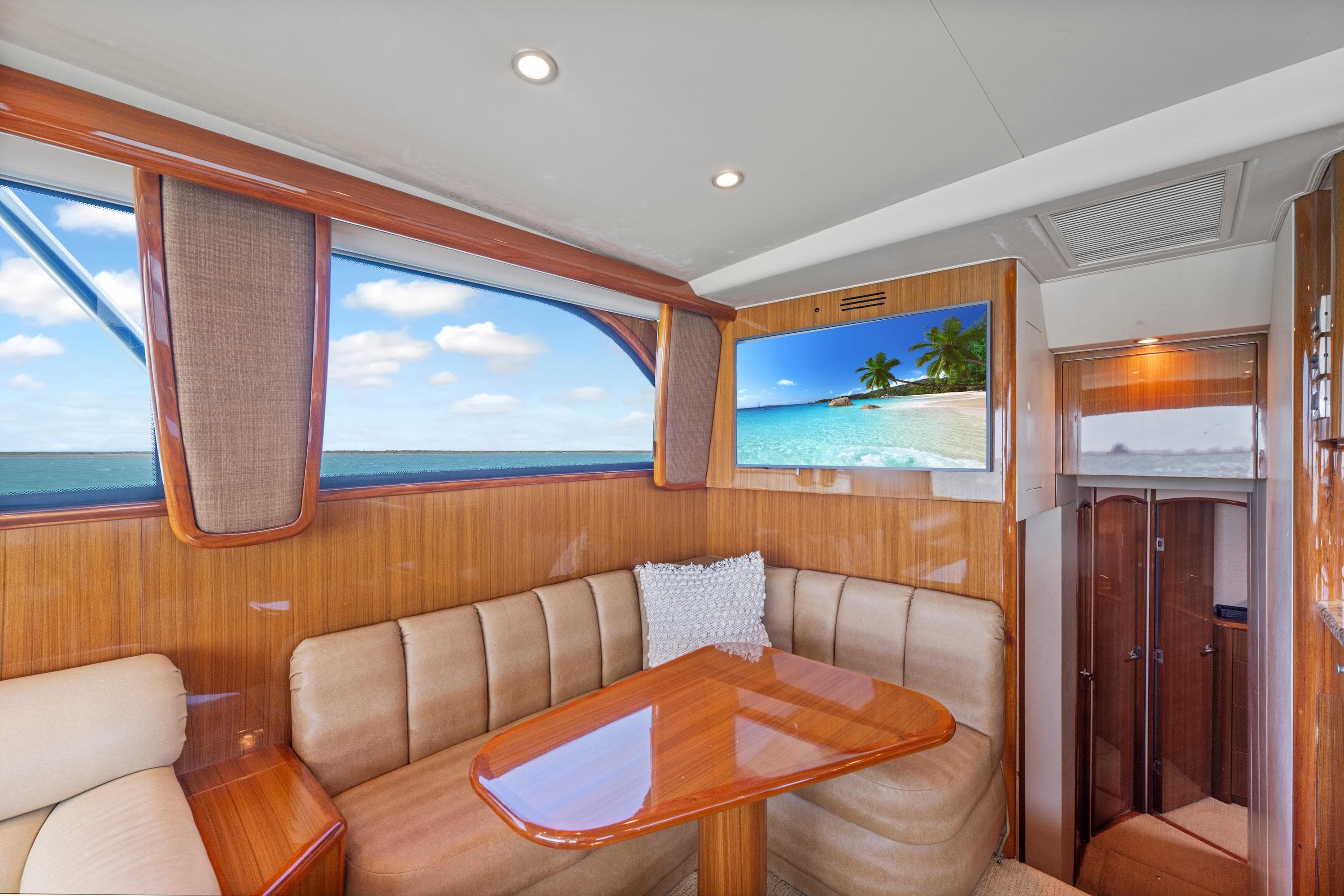 Luxurious interior of 2008 Viking Convertible yacht with plush seating and scenic window view.