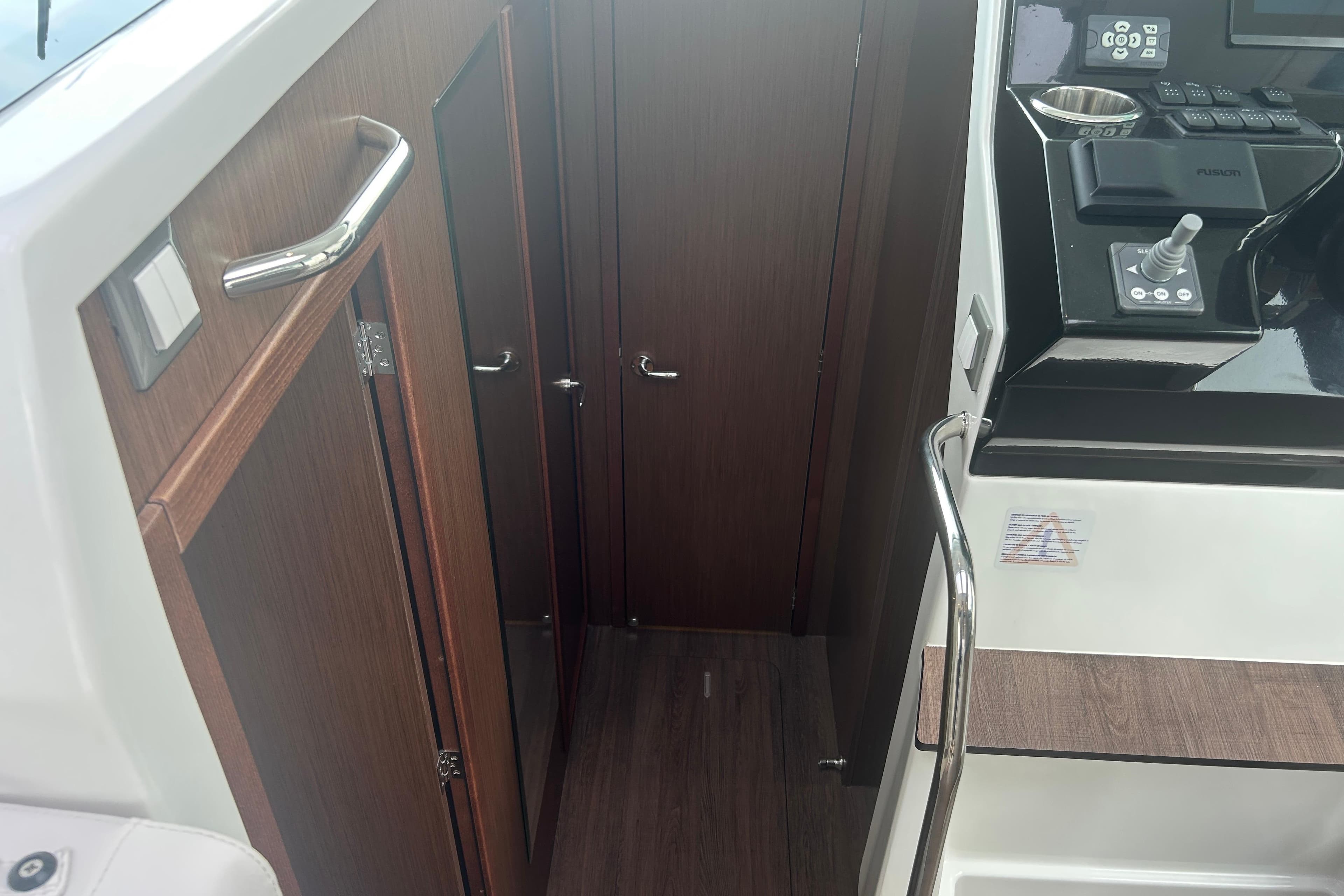 2025 Beneteau Antares 11 Coupe interior with wood finish and control panel.