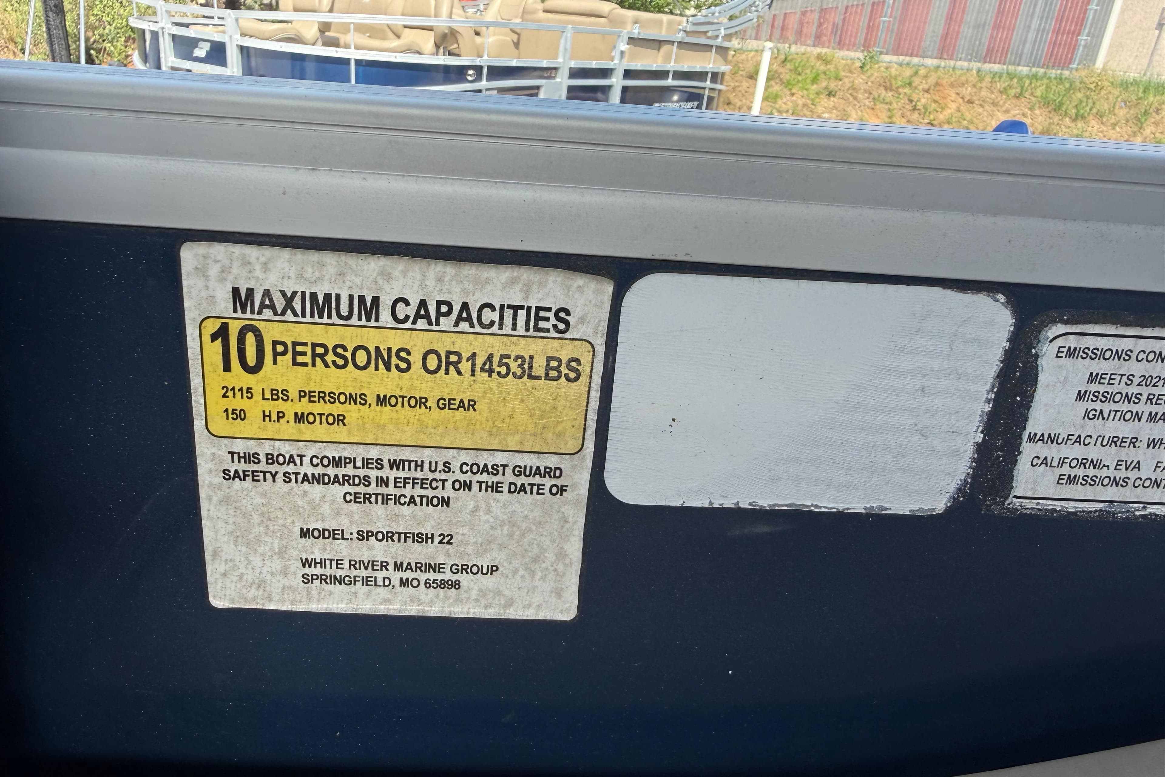 2021 Sun Tracker SportFish 22 DLX capacity label, 10 persons or 1453 lbs, 150 HP motor.