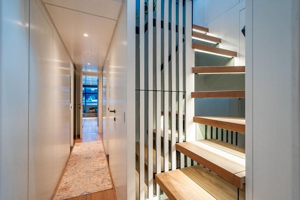 Modern interior of 2023 Bluegame BG 72 yacht with sleek staircase and hallway.