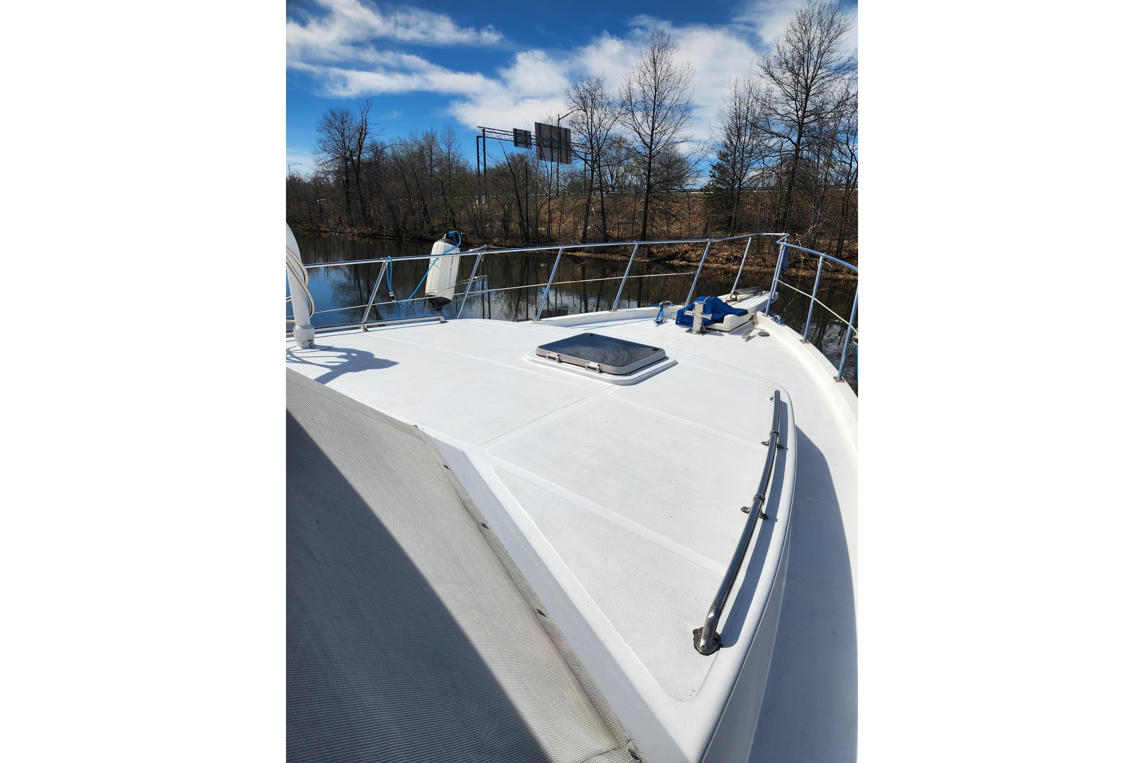 1987 Jefferson 42 SE Sundeck Motor Yacht deck view, surrounded by trees and calm water.