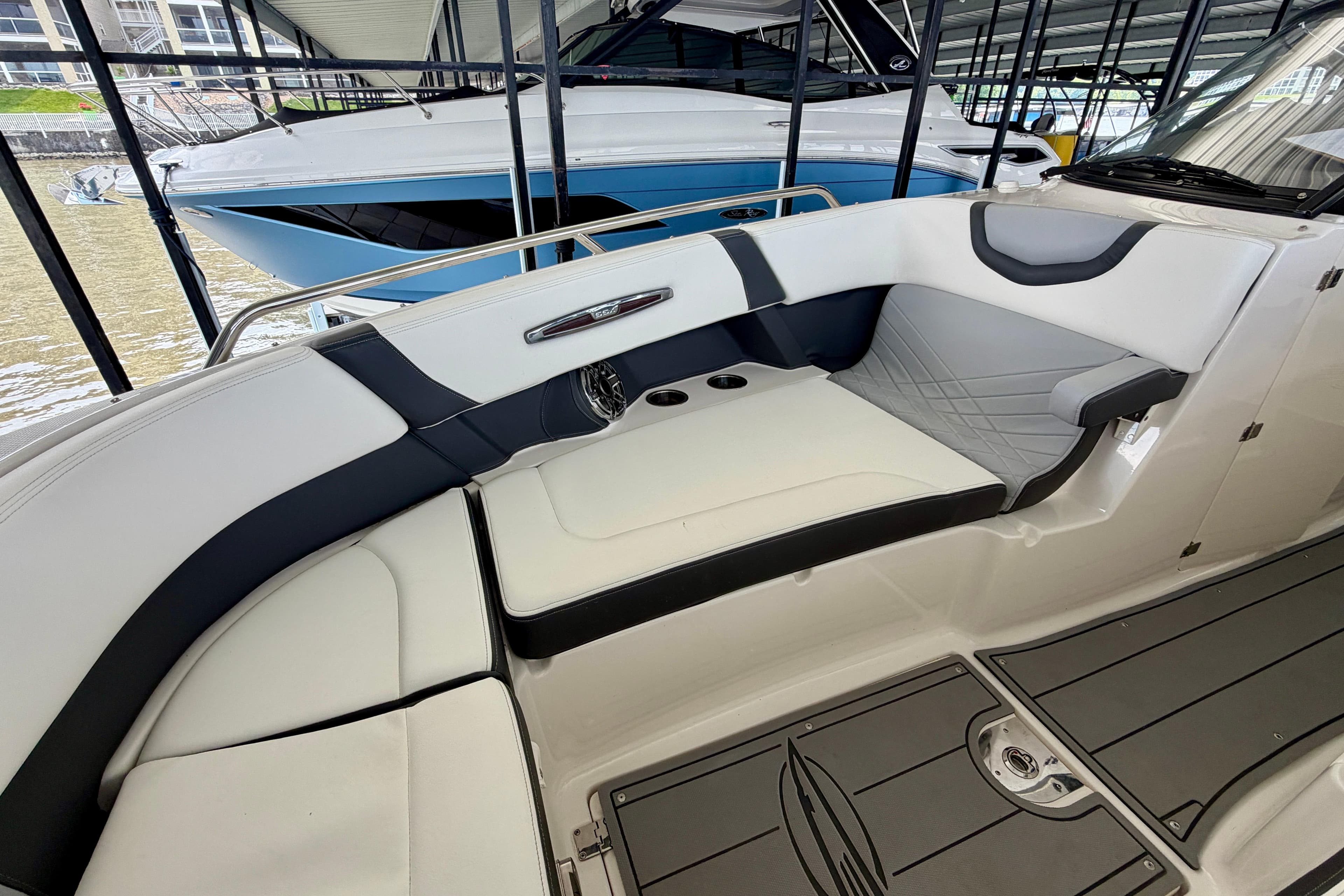 2022 Chaparral 317 SSX boat interior with white and gray seating in a marina.