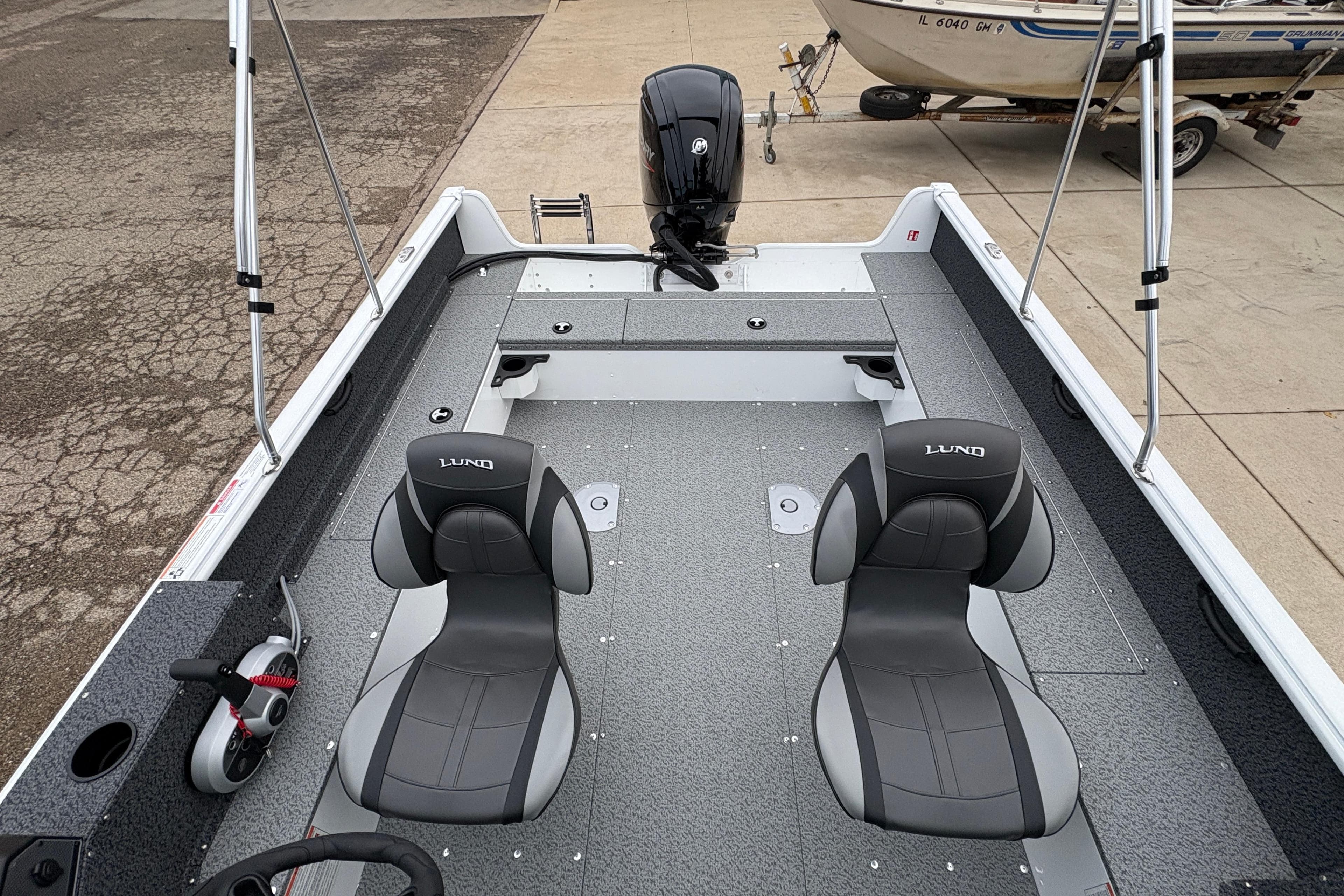 2026 Lund 1800 Explorer Sport boat interior with dual seats and motor.