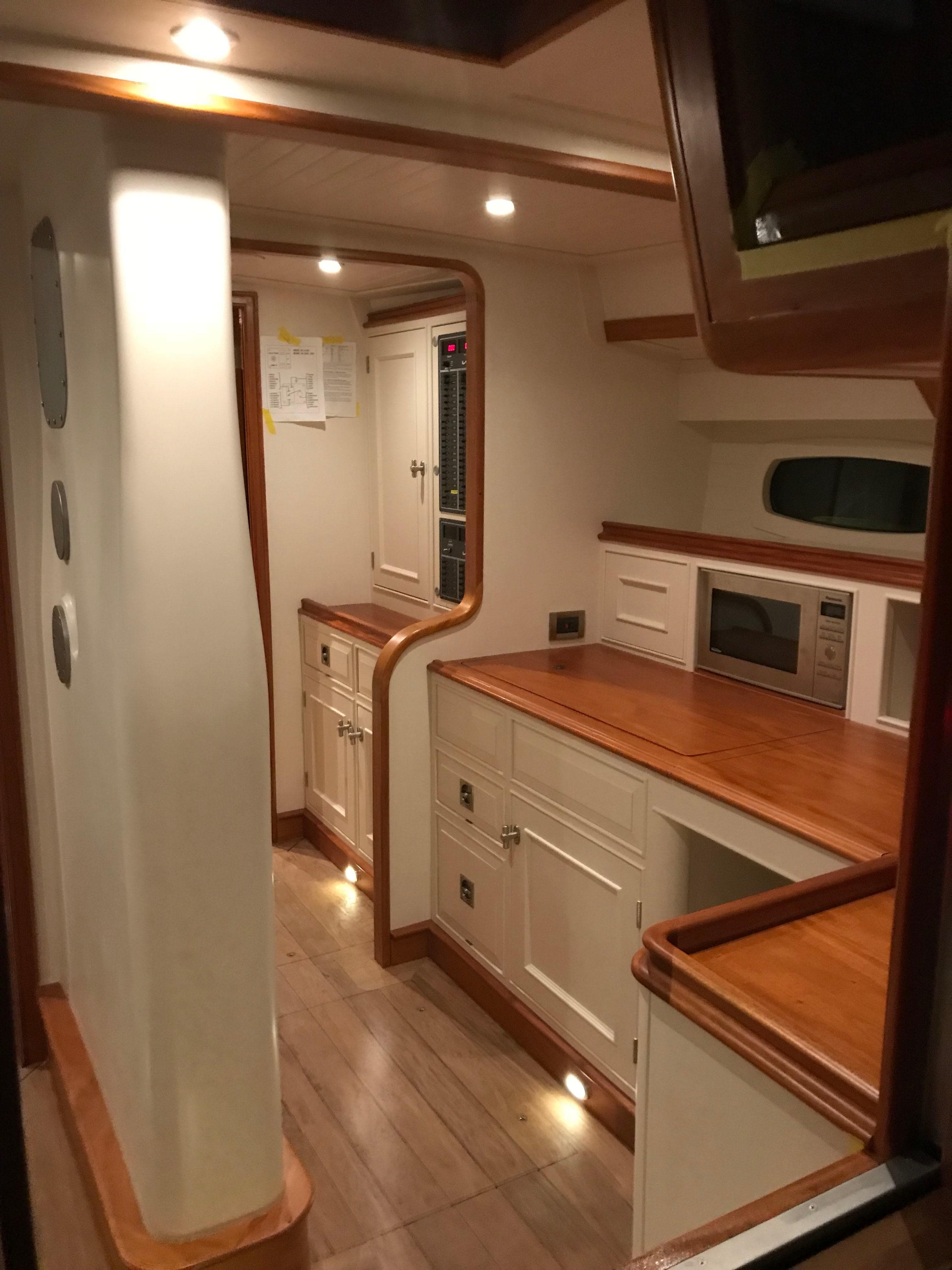 Luxurious interior of 2025 Surfari 50 yacht with modern kitchen and wooden accents.